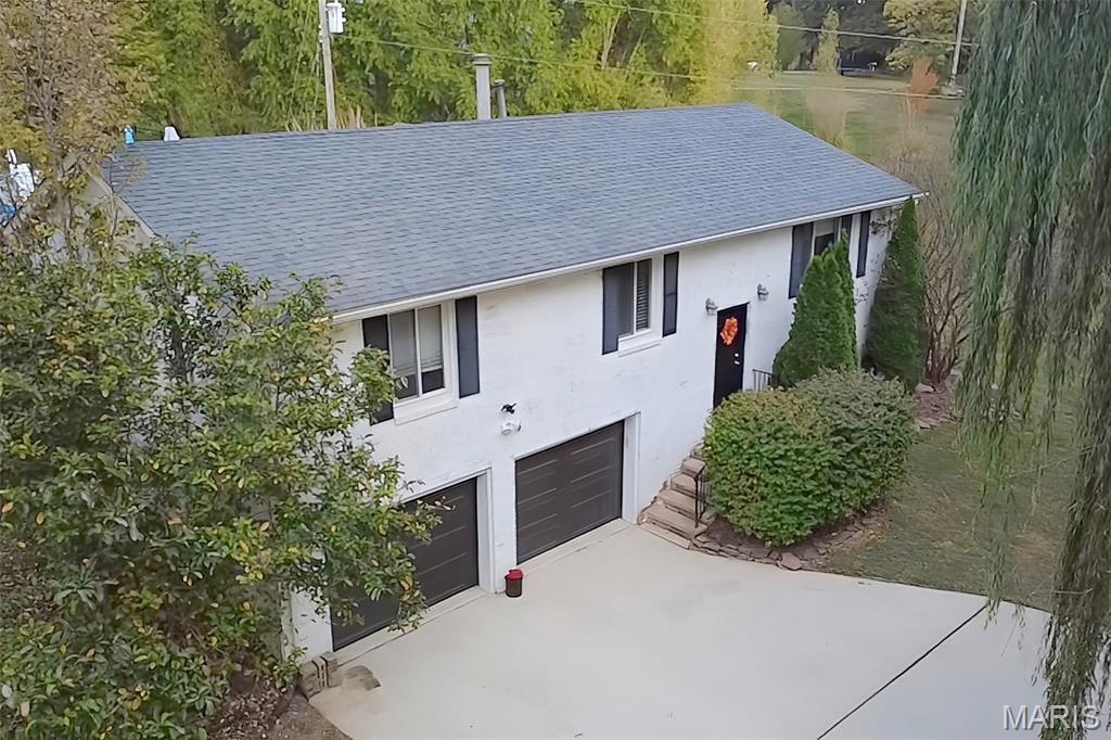 Rare opportunity to own private acreage right in the heart of Glen Carbon! This beautiful all-brick 4-bedroom home sits on approximately 2 secluded acres tucked into a peaceful, wooded setting while still being just minutes from everything town has to offer. Surrounded by mature trees and natural beauty, the property offers a rare sense of privacy and space that is hard to find within town limits. Inside, the home features an open floor plan with large windows that fill the space with natural light and provide beautiful views of the surrounding woods and evening sunsets. The updated kitchen features quartz countertops, a custom backsplash, and stainless steel appliances, and flows perfectly into the main living areas, making it great for everyday living or entertaining guests. Just off the kitchen, the covered patio creates the perfect outdoor living space to relax or host gatherings while overlooking the low-maintenance saltwater pool and private backyard. The lower level offers additional living space with a cozy family room, a large bedroom with a walk-in closet, a bathroom, and a laundry room - ideal for guests, extended living, or a private retreat. Additional features include an oversized 2-car garage with built-in storage shelves and a workshop bench. Located on a quiet dead-end street with direct access to the bike trail, this property combines privacy, convenience, and outdoor enjoyment all in one. Whether you're relaxing by the pool, enjoying the peaceful wooded surroundings, or hopping on the nearby trails, this home offers a truly special lifestyle opportunity in Glen Carbon.