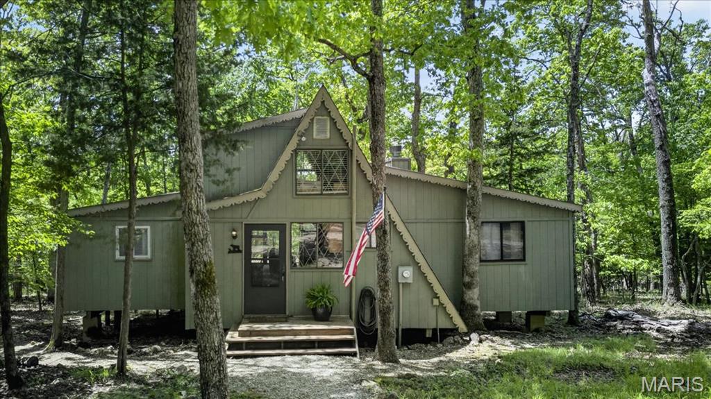 Tucked on 3.72 private wooded acres in the heart of Innsbrook, 190 Hirschweg Woods is the kind of classic A-frame retreat that never goes out of style. Just around the corner from the Farmhouse, this original chalet lives larger than expected with 2 main-floor bedrooms and a sleeping loft for 6—perfect for gathering, unwinding, and making lake-season memories.  Designed for easy entertaining, the thoughtfully laid-out interior features a tiny-but-mighty kitchen with elevated marble countertops, an adjoining dining area, and an open family room with a wood-burning fireplace that invites everyone to relax together. After a day on the water, the screened porch is sure to become your favorite hangout, while the tiered deck captures the peaceful wooded views and signature Innsbrook ambiance.  Ownership includes full access to Innsbrook’s resort-style amenities, including the clubhouse, fitness center, laundry facilities, 18-hole golf course, horseback riding trails, summer camps, concerts, and year-round events—everything you need to enjoy lake life in every season. Most furnishings included and golf cart negotiable.