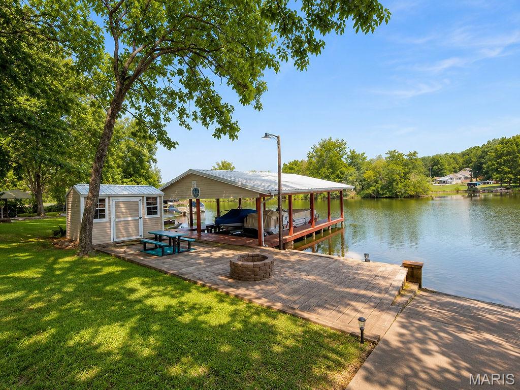 Waterfront Living at Its Best! This adorable ranch-style lake home offers approximately 1,100 sq. ft. of comfortable living space with an abundance of natural light and breathtaking views overlooking the lake. Whether you’re looking for the perfect weekend getaway or a full-time waterfront retreat, this property is ready to impress.

Outdoor entertaining is unmatched with a 23’ x 12’ upper deck, a 15’ x 44’ concrete patio & firepit just steps from the water, a private boat dock complete with two boat lifts and two boat slips, plus a charming gazebo that’s perfect for picnics or relaxing by the lake. A storage shed with electricity, an awning for shade, and a spacious outdoor setup make enjoying lake life effortless.

Inside, you’ll find a spacious kitchen with a breakfast bar, separate dining area, and a cozy living room featuring a wood-burning fireplace. The versatile den provides additional space for sleeping area, a game room, or a home office. The home also offers one bedroom, two full bathrooms, and a utility/laundry room with extra storage.

The circle concrete driveway provides ample parking for boats, side-by-sides, RVs, Razors, and all your lake toys. Situated in a desirable no-wake cove while overlooking the main channel, you’ll enjoy the best of both worlds—calm waters at your dock with beautiful views of the lake and nearby beach area.

The seller is motivated and ready to review offers. There’s still plenty of time to make this your lake getaway and enjoy the rest of the summer on the water!