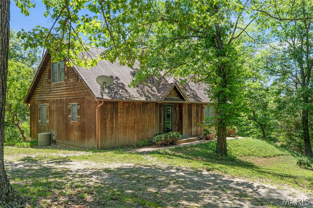 Home is located just north of Marthasville MO. in desirable Walnut Crest. Situated on 5+ acres this Rustic Style exterior blends nicely with the wooded setting. 1 1/2 story Home is ready for your updates/restoration. Seller will be selling in as is/where is condition. There is an oversized detached garage and a very nice covered deck. Maybe this is the country home to make your own.