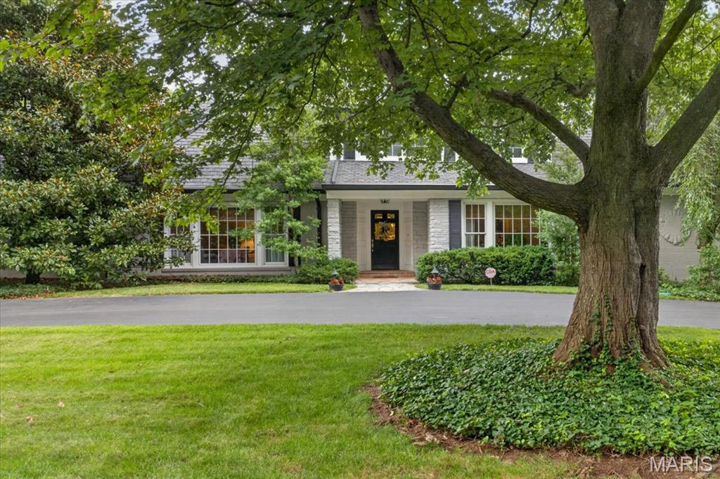 Welcome to this exceptional Ladue residence, where timeless elegance meets modern comfort. Privately nestled behind mature evergreens and lush landscaping, this beautifully maintained 3-bedroom, 5-bath home offers a serene retreat in one of the area's most desirable locations.
A gracious entry foyer featuring a stunning custom front door and dual coat closets opens to an inviting living room and formal dining room, both enhanced by floor-to-ceiling windows that fill the home with natural light. The warm and welcoming family room showcases a gas fireplace flanked by custom shelving, a wet bar with cabinetry, and a wall of windows with an oversized sliding door that seamlessly connects indoor and outdoor living.
The updated eat-in kitchen is thoughtfully designed with 42-inch cabinetry, Quartzite countertops and backsplash, abundant storage, and a bright breakfast area surrounded by windows overlooking the beautifully landscaped backyard and pool. A convenient powder room is located just off the kitchen.
The main-level primary suite provides a peaceful retreat with 2 custom walk-in closets and the rare luxury of 2 ensuite bathrooms. Upstairs, a cozy loft area is accompanied by two spacious bedrooms and a full bath.
Beautiful hardwood floors extend throughout the main level, complemented by a private office, main-floor laundry room, mudroom with a full bath, perfect for the pool, and a large walk-in storage closet. Outside, enjoy the expansive patio, sparkling pool, and private backyard oasis designed for relaxation and entertaining.
Additional highlights include an oversized two-car garage with new concrete flooring and custom storage shelving, a newer roof and exterior fence (2020), a newer water heater, and a newer gas meter. This fabulous home offers an abundance of storage, with all of the large closets and expansive, immaculate unfinished lower level.
Ideally located just minutes from Clayton's premier shopping, dining, and business district, with convenient highway access, this timeless Ladue home offers the perfect blend of privacy,