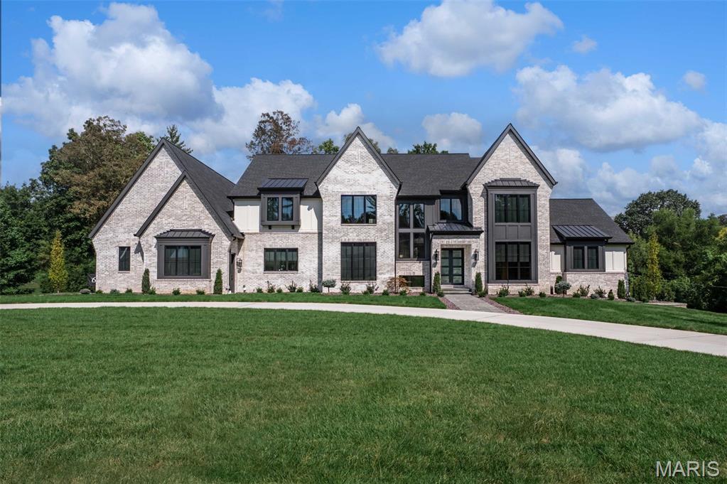 Introducing the Hawthorne at Ballas Ridge by Kemp Signature Homes. Offering over 5,000 sq. ft. on the main level, this transitional-style residence blends refined luxury with versatile living. Nestled within Des Peres’ most exclusive new enclave—featuring just four estate homesites ranging from 1.59–6.5 acres—the Hawthorne delivers both elegance and privacy. A soaring two-story foyer and vaulted great room create a dramatic entry, while the main-floor owner’s suite offers a spacious walk-in closet and spa-inspired bath. The main level boasts 10-foot ceilings, wide-plank hardwood floors, and exquisite millwork. At its heart, the chef’s kitchen with top-tier appliances flows seamlessly into the hearth room, while a covered patio with fireplace extends living outdoors. Upstairs, three ensuite bedrooms, a loft, and a second laundry room provide comfort and convenience for family and guests. The optional finished lower level unlocks endless possibilities—wet bar, recreation room, golf simulator, exercise studio, guest suite, or pool bath—allowing you to fully customize your lifestyle.
Ballas Ridge combines natural beauty—rolling terrain, mature trees, and a pond—with unmatched access to top schools, boutique shopping, dining, hospitals, and major highways.