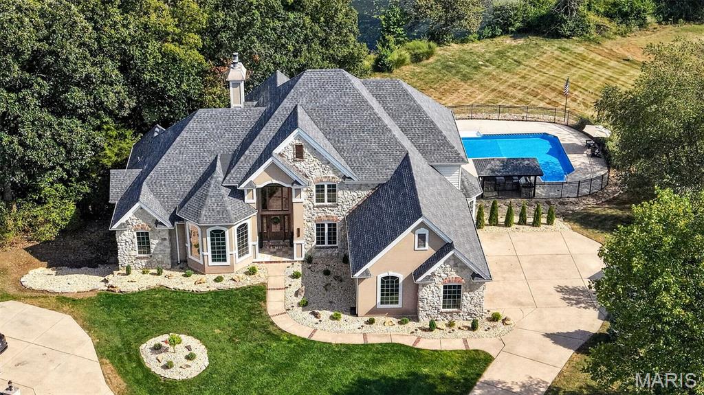 Welcome to 2314 Longest Drive, where impressive space, beautiful views and extensive NEW updates come together in one truly exceptional home! Perfectly positioned on a cul-de-sac lot in Bear Creek, this stunning 1.5-story home backs to the golf course & pond AND has it's own inground salt water pool, creating the perfect space to relax or entertain year round. Step inside and prepare to be wowed by the dramatic two-story living room, where soaring floor-to-ceiling windows fill the space with natural light. Brand-new flooring and carpet flow throughout the home, creating a fresh, sophisticated feel. The completely renovated kitchen is a true centerpiece, featuring brand-new high-end cabinetry, beautiful new countertops, new appliances, walk in pantry, and an adjoining eat-in area & den overlooking the backyard. The main level offers an abundance of living space with a dedicated office, formal dining room, main floor laundry and multiple gathering areas. The spacious main-level primary suite provides a private retreat with plenty of room to unwind with a sitting area, beautiful spa like en-suite and walk-in closet. Upstairs, an open loft overlooks the living space below and offers the perfect bonus area for relaxing, studying, or creating an additional lounge. Two roomy bedrooms share a full bathroom in the hall while the third upper bedroom has it's own updated en-suite and huge walk in closet. The finished walkout lower level takes this home to another level! Gather around the fireplace, play a game of pool or watch some football in the expansive recreation and living area, or take advantage of the FULL SECOND KITCHEN with bar seating —ideal for entertaining, extended guests, or multigenerational living. The lower level also includes an additional bedroom, full bath, dedicated home gym area, and generous storage space. Relax or entertain outside in your in-ground salt water pool, around the firepit, cooking in the outdoor kitchen or taking in the spectacular golf course and lake views on your brand new deck! With the outdoor entertaining on the .63-acre lot, and oversized 3-car garage, the exterior is just as impressive as the interior.
With approximately 5,760 square feet of total living space, 5 bedrooms, 4.5 baths, multiple living and entertaining areas, and extensive updates throughout, this is so much more than a beautiful home.. it's the perfect place to live, work and entertain.