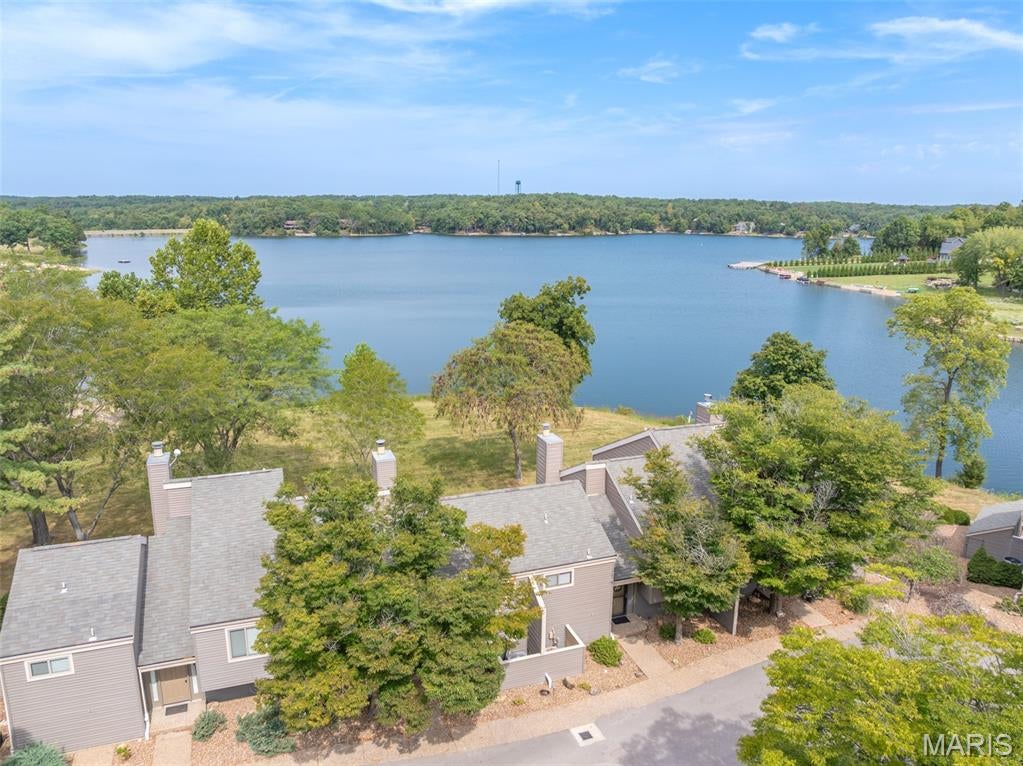 This exceptional two-bedroom condo offers one of those special settings that is hard to find, with fantastic views of beautiful Lake Aspen and direct lake access just steps from your door. Whether you're looking for a carefree second home, a full-time residence, or a place where the whole family can gather and make memories, this condo makes lake living easy. Step inside and you'll immediately notice the impressive vaulted entry foyer, accented by beautiful decorative cedar tongue-and-groove. The main level opens into a comfortable living area where large windows showcase the lake view and a wood-burning fireplace creates a warm gathering spot. Notice the cute dining area and direct access to the private deck. It's an ideal place to enjoy your morning coffee or watch the sunset. The heated and cooled all-seasons room takes unwinding to another level. Rustic finishes give the room a relaxed Innsbrook feel. It will become favorite spot to settle in with a book, watch TV, or keep an eye on the lake while the family enjoys the outdoors. The remodeled and enlarged kitchen is both roomy and functional, featuring custom cabinetry, plenty of counter space, and a huge breakfast bar that provides additional seating. Beautiful tile and hardwood flooring extend throughout much of the condo. Upstairs, you'll find two spacious bedroom suites, each with its own private bathroom, vaulted ceiling, and upgraded tile shower. The guest bedroom has an added bonus that is sure to impress: its own private deck overlooking Lake Aspen. Imagine opening the door in the morning and stepping outside to enjoy the view before the day even begins. Thoughtful updates have also made this condo especially functional. The original main-level half bath was converted into a full bathroom, making post-beach clean-up easy and convenient. The laundry room was relocated to the upstairs bedroom closet, creating an additional bonus/flex room on the main level. While this space cannot be counted as a bedroom, it offers plenty of possibilities for an office, game room, hobby space, storage, or whatever best fits your lifestyle. And then there's the lake! Lake Aspen is literally just feet away. Fish, swim, kayak, paddleboard, sail, or simply relax and enjoy the view. A large sand beach is right next door, making it easy for the family to spend the day by the water. Let the kids or grandkids swim out to the dock while everyone else enjoys a little sunshine on the beach. This is also one of the best places at Innsbrook to watch the annual Fourth of July fireworks. Invite the family, fire up the grill, settle onto the deck, and appreciate the show from your own incredible vantage point. You may just become everyone's favorite host! The condo comes fully furnished, with only a few exclusions, so you can arrive, unpack, and start enjoying lake life right away. The attached two-car carport provides convenient covered parking and plenty of room for storing your future golf cart, boats, kayaks, paddleboards, and other lake toys. Best of all, this condo has been meticulously maintained by the same owner for 31 years.  It's easy to appreciate the pride of ownership throughout. Now it's ready for the next generation to begin creating their own Innsbrook memories. Low-maintenance condo living. Fantastic lake views. Direct access to Lake Aspen. A beach next door. Room for family and friends. And an easy way to enjoy everything Innsbrook has to offer.  Whether you're ready for a second home, a full-time retreat, or a place where the family can gather for years to come, this one deserves a closer look.