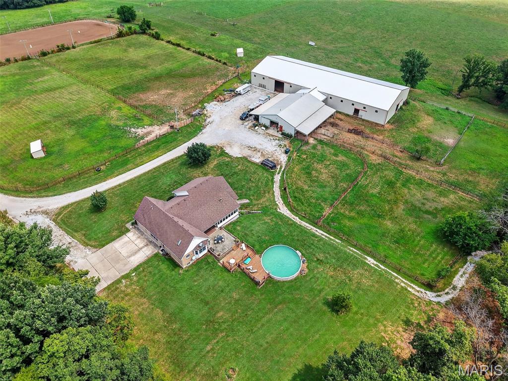 Motivated Seller! Equestrians Dream Estate on 24+ sprawling acres! Welcome to your private country retreat. Step inside this beautifully maintained ranch home to a spacious, open floor plan featuring 4beds/4 full baths, vaulted ceilings, expansive living area,  a large kitchen island, formal dining room & main floor laundry. With two primary suites and A partially finished walk-out basement offering additional living space with kitchenette, bonus room, & rec room, this home offers the best options for multi generational living! The 3 season porch is perfect for morning coffee or just relaxing, while the large patio, deck & above ground pool will be the highlight of family celebrations. With over 5600sqft of finished living space, the possibilities are endless!  Horse lovers will fall in love with the thoughtfully designed, heated barn, complete with 8 spacious 12x16 stalls, a large tack room, wash stall and full bathroom.  Ride year round in the impressive 80x200 indoor riding arena, take advantage of the 150x250 Lighted outdoor arena with 16 50K lumen lights, or let your horses enjoy the expansive, fully fenced turnout pastures. The back pasture has a small pond, and gently rolling landscape.  Just minutes from Hwy 70, multiple stores, Wentzville & Foristell shopping, and only 45min to Lambert airport!
