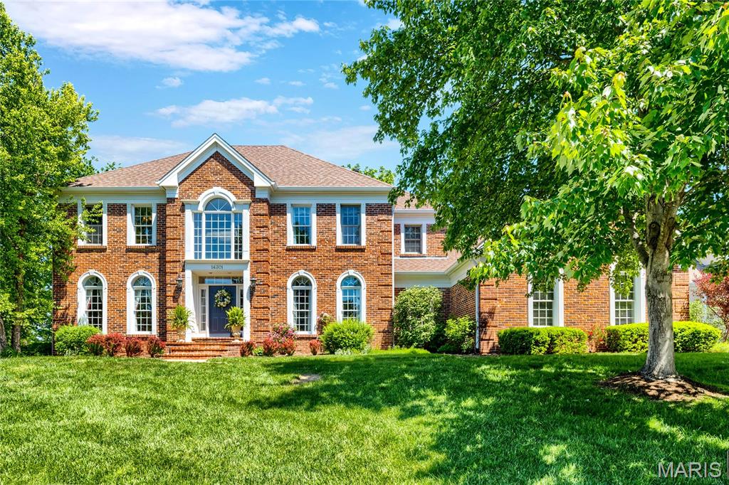 Stately 2-sty brick Colonial in prestigious Manderleigh of Town & Country. This Miceli-built home features exceptional craftsmanship & distinctive design elements throughout including hardwood flooring, palladian windows & custom trim work accents. Impressive 2-sty foyer highlighted by flared staircase leads to well-appointed study with French doors, elegant dining room and spectacular living room with marble fireplace, wide bay window, wet bar & atrium door that opens to expansive deck. Spacious open kitchen with 42” white cabinetry, butterfly center island, butler’s pantry & convenient planning center adjoins light-filled breakfast room & hearth room with beamed cathedral ceiling & brick fireplace. Coffered primary bedroom suite with luxury bath with jetted tub offers an appealing retreat. Front & rear staircases access 3 additional bedrooms, 1 with ensuite bath & 2 with Jack n’ Jill bath. Lower Level entertainment space includes family room with tiled fireplace, built-in bookcase & wet bar & game room plus office, workout room & full bath.  Situated on a private lot backing to woods with patio, composite deck that spans the rear of the house & 3-car garage.