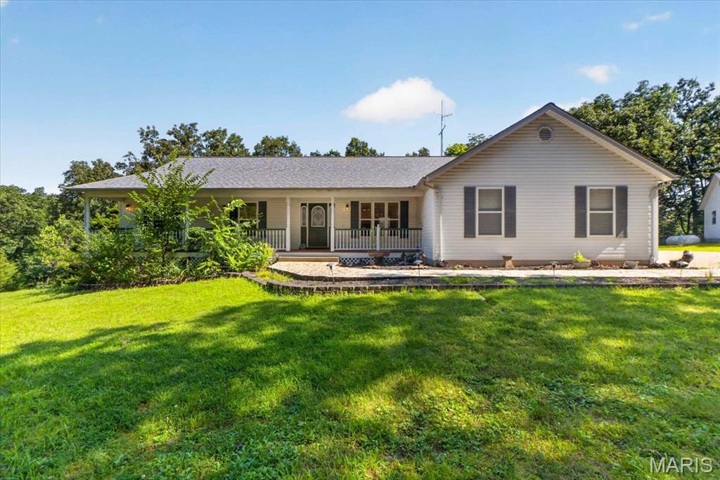 Welcome to 2711 Spotted Horse Trail—where peace, privacy, and quality craftsmanship come together on 11.05 breathtaking acres. If you’ve been dreaming of a beautiful home with room to spread out, this one checks all the boxes.

Pride of ownership is evident from the moment you arrive. Surrounded by peaceful woods and a picturesque, park-like setting, you’ll love unwinding on the inviting covered front porch or entertaining on the expansive deck while taking in the beauty of your own private acreage.

Step inside to find gleaming hardwood floors, soaring vaulted ceilings, elegant wood archways, and an abundance of natural light throughout. The spacious kitchen is both beautiful and functional, featuring custom 42-inch oak cabinetry with glass-front accents, cooktop with vented grill, track lighting, and plenty of workspace for cooking and gathering. The great room offers a beautiful bay window with French doors leading outdoors, while the formal dining room is perfect for hosting holidays and family dinners.

The spacious primary suite features French doors, his-and-hers walk-in closets, and a relaxing retreat at the end of the day. You’ll also appreciate the convenience of a main-floor laundry and mudroom, central vacuum system, multiple linen and coat closets, and quality finishes throughout the home.

The finished walkout lower level expands your living space with impressive 8½-foot ceilings and a half bath, making it ideal for entertaining, guests, or a family recreation area.

Car enthusiasts, hobbyists, and anyone needing extra workspace will fall in love with the garage setup! In addition to the oversized heated attached two-car garage, the heated detached workshop is truly a dream. It features a 16’ x 9’ electric overhead door, soaring 11-foot ceilings, attic storage with pull-down stairs & overhead monorail system.

Located just 6 miles from I-44, you’ll enjoy the perfect balance of country living and everyday convenience. With 11.05 private acres, exceptional care, and incredible amenities, this is more than just a home—it’s a lifestyle. Schedule your private showing today!