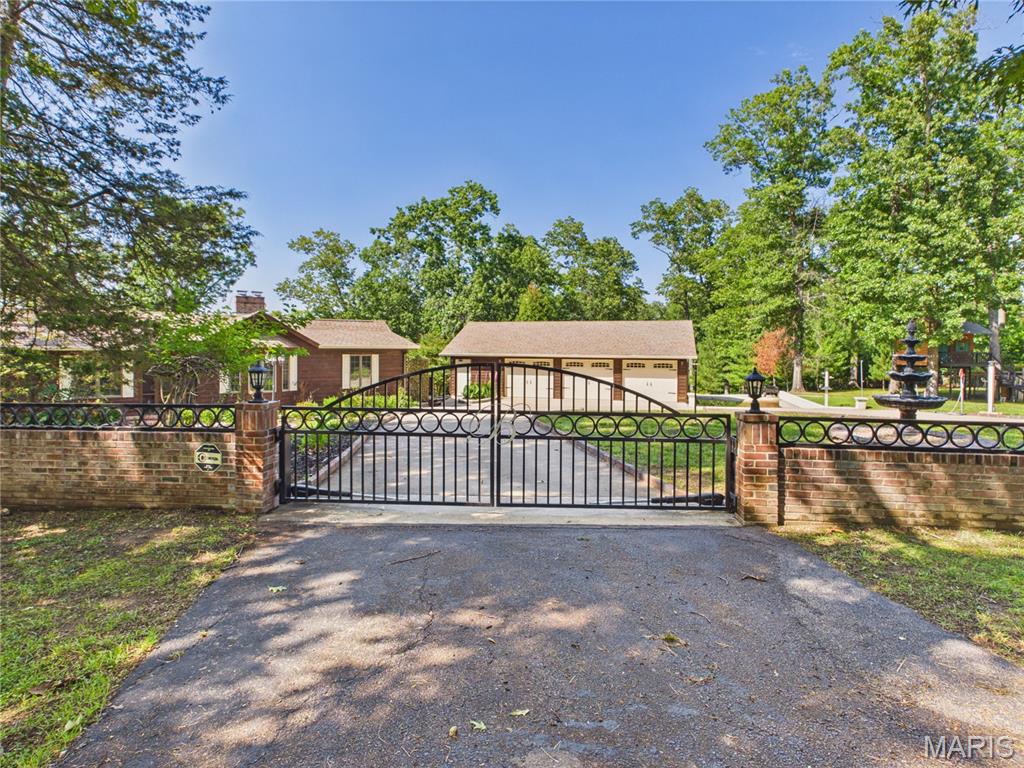 Welcome to this completely updated ranch home tucked away on nearly four beautifully fenced, scenic acres in the Lock Loma subdivision. Finding a property that successfully combines this level of space, quality upgrades, privacy, and community lake privileges is an absolute rarity.
Inside you will find a thoughtfully designed layout featuring three bedrooms and three full bathrooms. Fresh flooring, clean paint, and two massive stone fireplaces anchor the main living areas with incredible warmth and rustic character. The kitchen serves as a central showcase with its custom oak cabinetry and accent stonework, perfectly blending country charm with high end finishes. For year round enjoyment, the screened and covered patio spaces offer a peaceful spot to relax and take in the beautiful, tree lined views.
The outdoor amenities are just as impressive as the interior. A detached three car garage features its own heated and cooled workshop area, providing the perfect flex space for a home business, hobbies, or extra storage. The manicured grounds are exceptionally maintained with a multi zone irrigation system on timers, stone walkways, and a grand circular driveway. Security and peace of mind are built right in with an electric gate guarding the private entrance. Complete with a professionally built treehouse for extra character, this fully loaded retreat offers a rare country lifestyle with modern comforts.