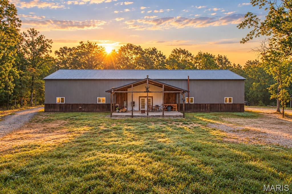 Big Kuntry Farms is a versatile 45+ acre property for sale in Washington County, Missouri, located just southwest of Old Mines along Highway 21. Combining a newly constructed barndominium with wooded acreage, hunting land, recreational property, and an extensive trail system, this property offers an exceptional opportunity for a permanent country home, weekend getaway, hunting retreat, homestead, or private ATV property.

A deeded gravel driveway leads to the centerpiece of the property: a 100-by-42-foot barndominium constructed in 2025. Built on a 6-inch concrete slab, the fully finished structure features 16-foot walls, full spray-foam insulation, and complete utilities. The versatile floor plan combines comfortable living space with substantial garage, equipment storage, workshop, and entertainment areas.

A pitched front porch with custom barnwood trim opens into the expansive garage and entertaining area. Two oversized garage doors provide convenient access, including one tall enough to accommodate a high-end RV. The garage features custom-finished floors with French drains, along with a dedicated bunk room with a kitchen sink and full bathroom, providing additional space for a guest.

The main residence features custom hardwood finishes, hardwood flooring, carpeting, and an open, lofted living area and kitchen. The home includes two spacious bedrooms, two full bathrooms, a laundry room, and ample storage. Above the garage, a large lofted bonus room is already plumbed for an additional bathroom. This unfinished space offers flexibility for additional bedrooms, a game room, home office, bunk room, or private recreational area.

Along the north side of the building, a 100-foot covered overhang provides substantial equipment storage and could also be converted into an outdoor living, entertaining, or gathering area.

The surrounding Washington County hunting and recreational acreage includes mixed hardwood timber, a creek bottom, previously-established food plots, and an extensive trail system. UTV-accessible trails extend around the property’s perimeter, providing convenient access for hunting, ATV / UTV recreation, wildlife management, and property maintenance. 

With a combination of barndominium living, hunting acreage, hardwood timber, trails, and quiet setting, Big Kuntry Farms offers a rare opportunity to own a private rural escape in Washington County, MO. The property is conveniently located within approximately an hour of St. Louis County and the Highway 44 corridor while providing the privacy and space of a country setting.