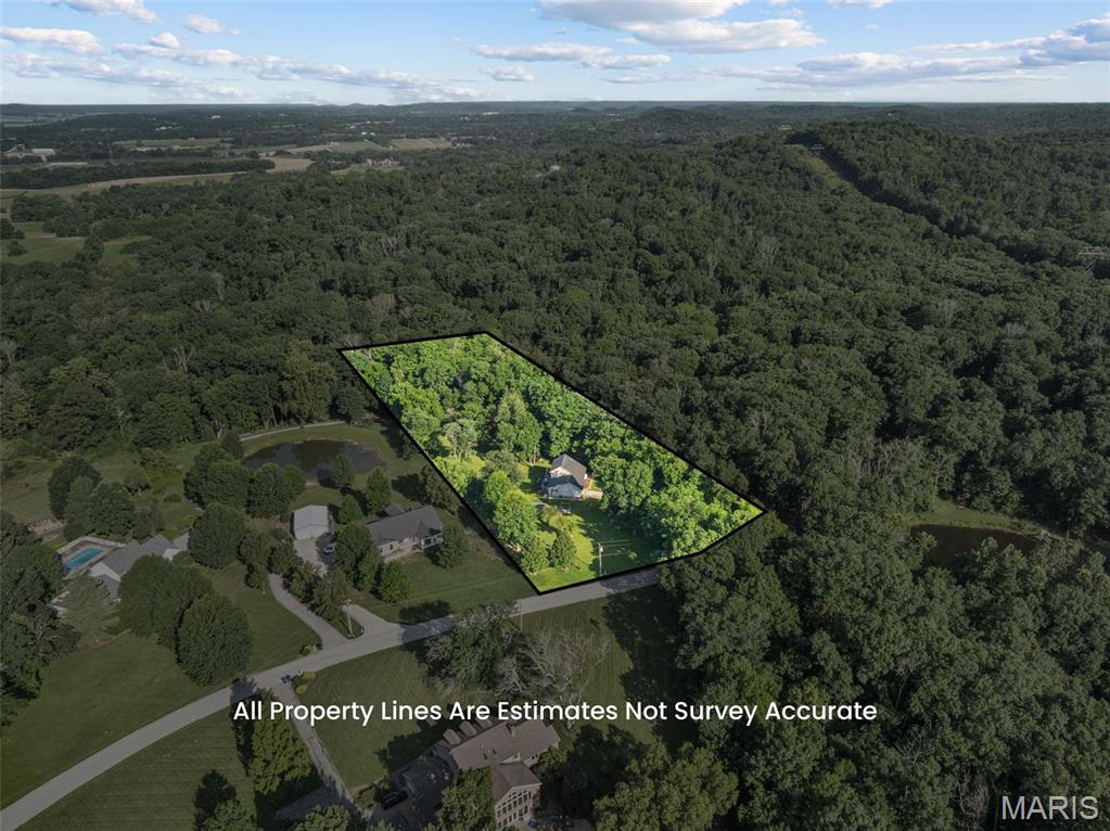 Welcome home to the perfect blend of peaceful country living and modern comfort! Nestled on 4.18 scenic acres in the highly sought-after Washington School District, this impressive 4-bedroom, 3 full bath, 1.5-story home offers privacy, space, and breathtaking views of a neighboring lake—all while providing the convenience of a move-in ready home with extensive updates.

Step inside to an inviting open-concept floor plan featuring luxury vinyl plank flooring throughout the main living areas and a stunning shiplap feature wall showcasing a cozy electric fireplace. Take in serene views with all the living room windows letting in natural light. The spacious kitchen is designed for both everyday living and entertaining with a center island offering seating, double sink, dedicated coffee bar station, abundant cabinetry, and easy access to the expansive 40-foot composite deck overlooking the picturesque countryside.

The oversized primary suite is a true retreat with a large walk-in closet and private ensuite bath. A second main floor bedroom, currently utilized as a home office, provides flexibility for guests or work-from-home needs. An updated full bathroom with walk-in shower and convenient main floor laundry complete the main level.

Upstairs you'll find two enormous bedrooms, each featuring walk-in closets, along with a charming bonus playroom that also makes an excellent craft room, reading nook, or additional storage space. A third full bath completes the upper level.

The finished walkout lower level offers exceptional additional living space with an expansive family room, dedicated finished office/flex room (ideal for a home office, hobby room, workout space, or safe room), plus a separate unfinished room ready to become the perfect media or movie room. The oversized storage and utility area provides incredible functionality, and future bathroom addition in lower level is made easy with a ready framed, exterior-drywalled bathroom complete with rough-in plumbing ready for your finishing touches.

Outside, enjoy the beauty of nature from the covered patio featuring built-in privacy screens, or relax on the expansive composite deck while taking in peaceful lake views of neighboring property.  The fenced yard features 8ft gate entrance for easy access, mature shade trees, wooded backdrop, wet-weather creek, lean-to storage conveniently located on side of home, and abundant wildlife create your own private country oasis.

Recent improvements include all new windows (2025), two new double sliding patio doors, new sump pump, luxury vinyl plank flooring, and gutter guards. If you're looking for acreage, privacy, Washington Schools, and a home with room to grow, this exceptional property is one you won't want to miss. Minimal restrictions to protect your investment.
SELLER INCENTIVE! Seller is offering $5,000 toward Buyer’s closing costs and/or interest-rate buydown with an acceptable offer. PLUS, qualified buyers who choose Seller’s preferred lender may receive an additional lender credit equal to 1% of the loan amount, subject to lender terms, loan program and Buyer qualification.