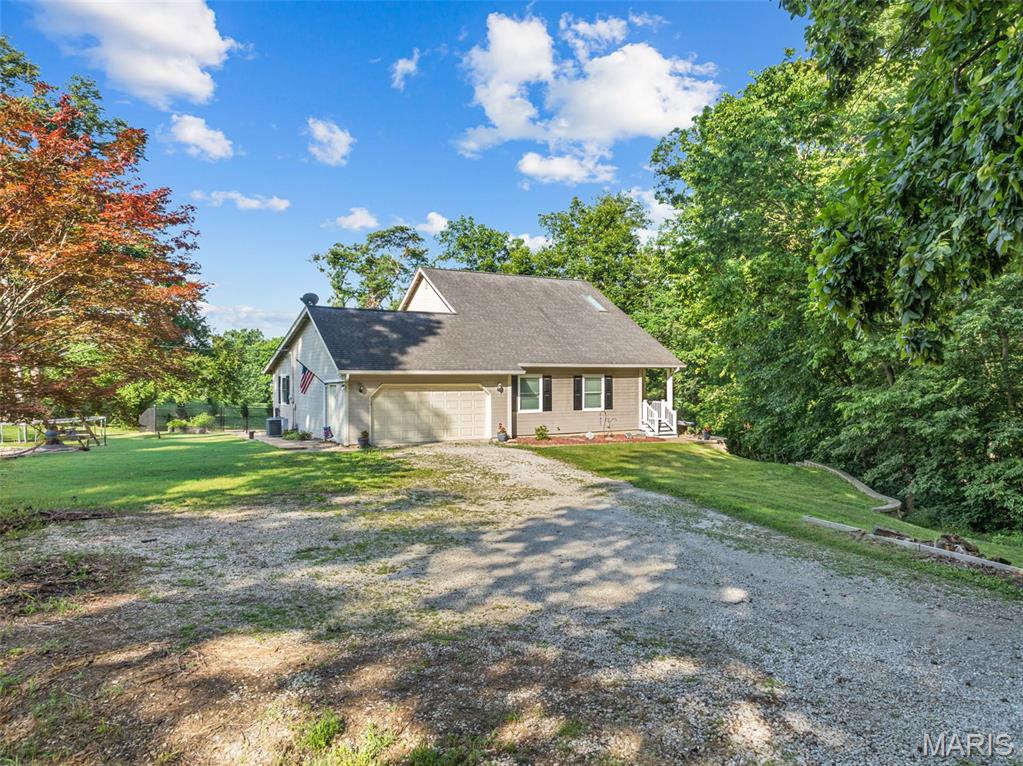 Welcome home to the perfect blend of peaceful country living and modern comfort! Nestled on 4.18 scenic acres in the highly sought-after Washington School District, this impressive 4-bedroom, 3 full bath, 1.5-story home offers privacy, space, and breathtaking views of a neighboring lake—all while providing the convenience of a move-in ready home with extensive updates.

Step inside to an inviting open-concept floor plan featuring luxury vinyl plank flooring throughout the main living areas and a stunning shiplap feature wall showcasing a cozy electric fireplace. Take in serene views with all the living room windows letting in natural light. The spacious kitchen is designed for both everyday living and entertaining with a center island offering seating, double sink, dedicated coffee bar station, abundant cabinetry, and easy access to the expansive 40-foot composite deck overlooking the picturesque countryside.

The oversized primary suite is a true retreat with a large walk-in closet and private ensuite bath. A second main floor bedroom, currently utilized as a home office, provides flexibility for guests or work-from-home needs. An updated full bathroom with walk-in shower and convenient main floor laundry complete the main level.

Upstairs you'll find two enormous bedrooms, each featuring walk-in closets, along with a charming bonus playroom that also makes an excellent craft room, reading nook, or additional storage space. A third full bath completes the upper level.

The finished walkout lower level offers exceptional additional living space with an expansive family room, dedicated finished office/flex room (ideal for a home office, hobby room, workout space, or safe room), plus a separate unfinished room ready to become the perfect media or movie room. The oversized storage and utility area provides incredible functionality, and future bathroom addition in lower level is made easy with a ready framed, exterior-drywalled bathroom complete with rough-in plumbing ready for your finishing touches.

Outside, enjoy the beauty of nature from the covered patio featuring built-in privacy screens, or relax on the expansive composite deck while taking in peaceful lake views of neighboring property.  The fenced yard features 8ft gate entrance for easy access, mature shade trees, wooded backdrop, wet-weather creek, lean-to storage conveniently located on side of home, and abundant wildlife create your own private country oasis.

Recent improvements include all new windows (2025), two new double sliding patio doors, new sump pump, luxury vinyl plank flooring, and gutter guards. If you're looking for acreage, privacy, Washington Schools, and a home with room to grow, this exceptional property is one you won't want to miss. Minimal restrictions to protect your investment.