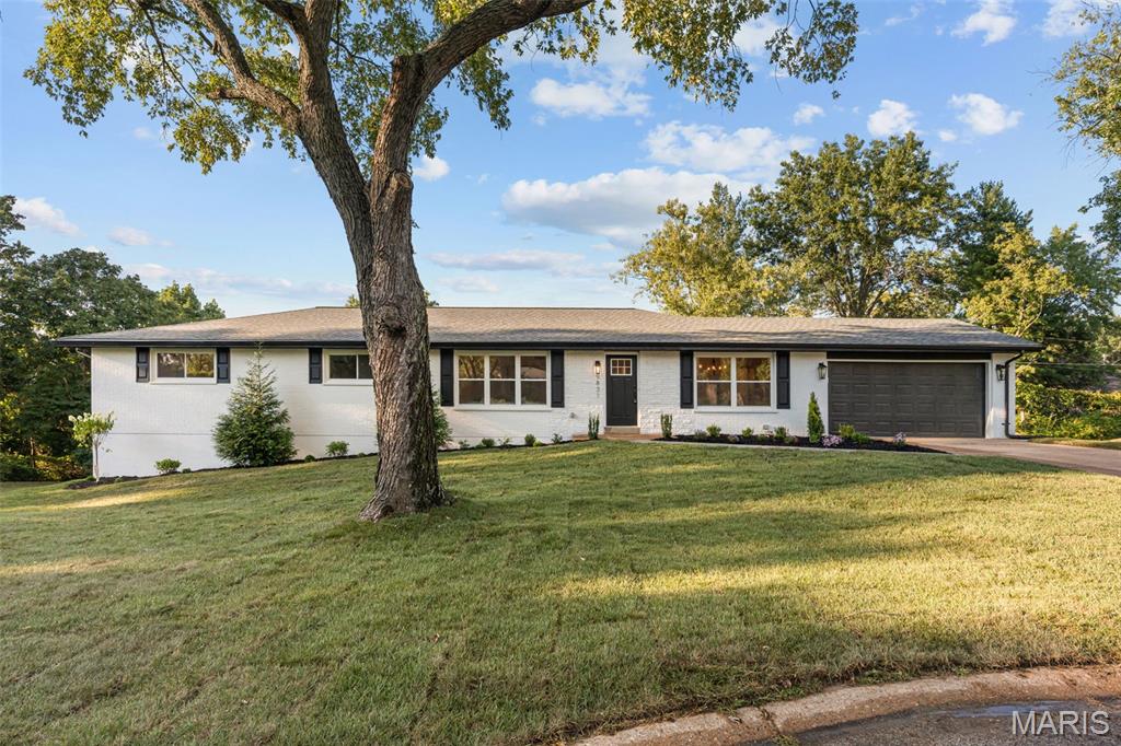 Welcome to this beautifully renovated brick ranch in Ladue Schools! Situated on nearly half an acre at the end of a quiet cul-de-sac in Creve Coeur, this home has 3,200+ square feet of thoughtfully designed living space. You’ll love the curb appeal with new landscaping, brick and stone detail, and updated shutters and light fixtures. The foyer opens to a bright dining room and vaulted living room, featuring stylish lighting and gleaming hardwood floors that continue throughout the main living space. The open layout of the family room and kitchen allows you to host gatherings with ease. The gourmet kitchen boasts top-of-the-line stainless steel appliances, quartz counters, island with breakfast bar, modern lighting, white cabinets with crown molding, black fixtures, and a timeless subway-tile backsplash. It flows seamlessly into the vaulted family room with a cozy gas fireplace. French doors lead to the light-filled sunroom addition. The primary suite is a retreat, with new carpeting, a walk-in closet with organization system, and a luxurious bathroom complete with a freestanding tub, step-in shower, dual-sink vanity with brushed gold fixtures, and gorgeous tilework. Two more bedrooms and another full bathroom with tile-surround tub, quartz vanity, and ceramic tile floors round out the main level. The walk-out finished basement adds a rec room, 4th bedroom, bath w/step-in tile-surround shower, and space for storage. Enjoy the fall weather on the patio overlooking the large backyard and trees beyond. Just moments from schools, parks, and all of the shopping and restaurants along Olive and Lindbergh, with quick access to I-170 and I-270, Westport, and Clayton, this home in a great location is one you won’t want to miss!
