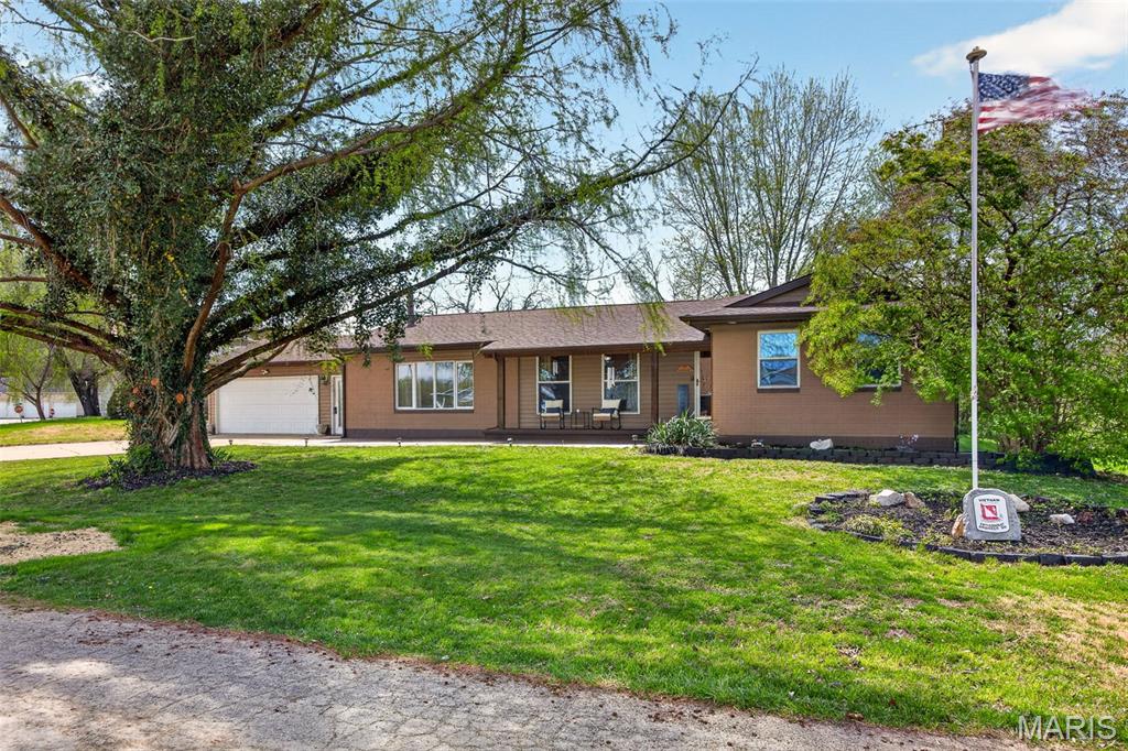 Come take a look!! You won't be disappointed! You will love this very roomy, move in ready ranch home with over 2300 sq ft, with awesome outdoor living areas, just waiting for new owners! You will love how spacious all the rooms are, including large great rm w/hardwood floors, gorgeous stone, floor to ceiling gas fireplace, ceiling fan and large window providing tons of natural light! Large dining room w/ceramic tile floors, can be used in any manner that works for you, whether for your formal dining set, another living area, office space, even a play room! Great kitchen includes breakfast area, hardwood floors, stainless appliances, custom tile backsplash, breakfast bar & ceiling fan! Glass French doors welcome you into the 4 season room that you will love, for use as another living area, exercise/yoga space, kids playroom or more, offering multiple sliding doors, allowing in so much sun, with walk out to covered deck (patio furniture stays!) and great backyard w/decking and huge patio, great yard space for the kids and pets, large shed & privacy fence! Oversized primary suite offers space for your largest furniture, large windows for extra light, ceiling fan, 2 closets incl walk in closet w/custom shelving & glass French doors open to 4 season room! Plus full bath w/barn doors, separate rm for walk in shower w/ceramic tile & toilet.  2 addl bdrms plus amazing full bath w/huge corner jet tub w/tile surround & window for more light! Washer & Dryer will stay in the large laundry/utility rm w/cabinets, counter space, closet and ceiling fan, and walk out to oversized & insulated garage & attic. Roof/gutters 1 yr old. High efficiency gas furnace! Huge 3 car wide driveway, awesome patio area in the front, adjacent to covered front porch! Choice Ultimate Home 1 year home warranty included! Large trees, flagpole, more! Small town country living, enjoying a river town with no concerns with flooding ever!