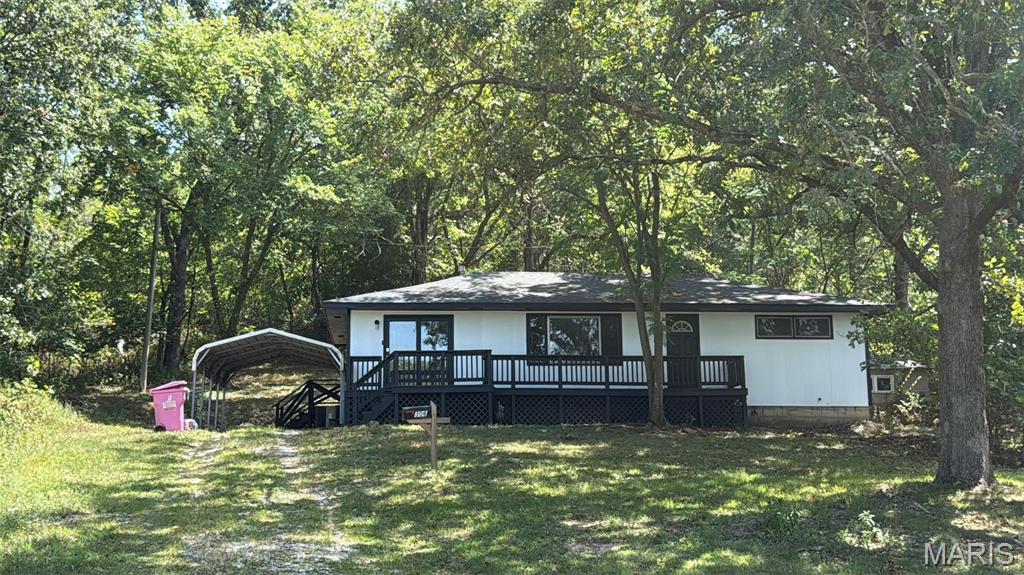Welcome to this adorable, move-in-ready Waynesville home that proves you don’t need a huge house to have plenty of room to enjoy life! Tucked away at the back of a quiet cul-de-sac, this renovated 3-bedroom, 1-bath home offers approximately 1,100 square feet of comfortable living space, a large lot, and the kind of peaceful backyard that might just convince you to put down your phone and go outside. The home has received plenty of updates, including newer luxury vinyl plank flooring, fresh paint, updated fixtures, wood siding, and an architectural shingle roof. Inside, you’ll find tons of natural light that makes the home feel bright, welcoming, and even more spacious. The layout offers three bedrooms, a comfortable living area, and a functional floor plan that makes great use of the square footage. Outside is where this property really gets to show off! The large deck is perfect for morning coffee, grilling dinner, entertaining friends, or simply sitting outside and pretending you’re going to tackle that weekend project tomorrow. The spacious backyard is surrounded by plenty of trees, offering privacy, shade, and room to play, garden, relax, or let the dogs burn off some energy. A storage shed provides extra space for lawn equipment, tools, bikes, and all the things you swear you’ll eventually organize. The 2-car carport provides convenient covered parking, and the home's location at the back of the cul-de-sac means very little traffic and a quieter setting while still being close to everything Waynesville has to offer. Whether you're searching for your first home, looking to downsize, or simply want an affordable, updated home with a large yard, this one deserves a look. And here's the best part: this home is priced to sell and qualifies for USDA and VA financing options with no money down for qualified buyers. Updated, affordable, tucked away on a large lot, and ready for its next chapter—this might just be the one you've been waiting for!