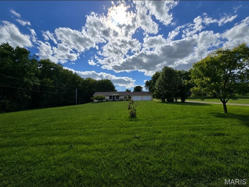Welcome home to your own private slice of country paradise! Nestled on 4.98± picturesque acres in the highly sought-after O'Fallon School District, this charming 3-bedroom, 3-bath ranch offers the perfect blend of peaceful country living and convenient access to Troy, O'Fallon, and Scott Air Force Base.

Enjoy breathtaking views of the stocked pond, home to multiple species of fish, making it a dream setting for fishing enthusiasts and nature lovers alike. The inviting home offers a spacious and functional floor plan with a warm, comfortable atmosphere throughout. Relax on the covered front porch or entertain family and friends on the backyard patio while taking in the beautiful country setting.

The kitchen comes complete with appliances, including a newer refrigerator, while the main-floor laundry includes the washer and dryer for added convenience. An oversized 20' x 24' attached garage provides ample storage and workspace.

Need room for all your toys, hobbies, equipment, or vehicles? This property delivers! The impressive 40' x 40' pole barn with electric service, workshop area, and loft storage offers endless possibilities. An additional chicken coop/dog kennel structure with covered storage space adds even more versatility.

Parking is abundant with space for multiple vehicles inside the attached garage and pole barn, plus an expansive driveway capable of accommodating approximately 14 additional vehicles. Whether you have an RV, boat, trailer, work vehicles, or frequently entertain guests, you'll appreciate the exceptional parking and storage opportunities this property provides.

Major updates include newer roof, siding, gutters, and refrigerator, offering peace of mind for years to come. The propane tank, washer, dryer, and kitchen appliances are included, making this home truly move-in ready.

If you've been dreaming of acreage, a stocked pond, outbuildings, incredible parking, and a beautifully maintained home in a prime location, this rare opportunity is ready for you. Schedule your private showing today before it's gone!