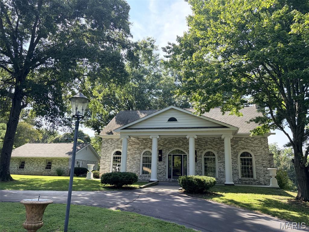 Nestled in the heart of Misouri Wine Country, sits this custom-built Southern Colonial, full brick, two story home on 8.78 acres. Just minutes from the Katy Trail in Dutzow, Missouri. This property offers a perfect blend of elegance, charm, and natural beauty!  As you drive up along the circular driveway, past the large water fountain, you will enter the 16' x 9' foyer with an 18' tall, vaulted ceiling which opens up to the balcony above.  Prominently featured are arched doorways with large wood trim, dental crown molding, and block wainscoting in both the formal dining room and grand room. Grand room with its wood burning fireplace, has three walls of arched windows. The formal dining room boosts an authentic crystal candle lit chandelier!  The seller was a very prominent collector who invested a lot into the custom draperies you will see in both of these formal rooms.  Kitchen impresses with solid mahogany cabinets custom made by Bill Hacker, vintage gas stove, Jenn-air down draft electric grill and French doors out to the patio and level back yard. Upstairs boosts the large primary bedroom with a second wood burning fireplace and large bath, as well as a second bed with en suite full bath.  The 7.38 acre lot next door is also available. Adding on a main floor west wing with primary bed, bath, and laundry, was always in the planning stage as well!  We are selling to settle the estate, and Trustee has never occupied the home.