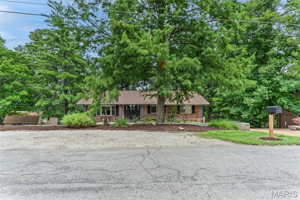 This quaint cottage style home sits on a quiet street just minutes from shopping and restaurants.  Walk into the living room and be welcomed by large windows to brighten the space and vinyl floors.  The short trip into the county style kitchen boasts new cabinets and fresh counters.  Stainless steel built in appliances.  Patio doors take you to a nice covered  deck and part two deck that is uncovered ready for flowers or sunning.  The large backyard is private and level enough for a playground.  Back inside to the 3 bedrooms that gives room for a family.  The primary bedroom includes a remodeled ensuite.  Next step down to the lower level and be pleasantly greeting by a large family room area that includes space for a game table or pool table,  wood burning fireplace and seating for watching the big game.  Keep moving and find the laundry space, 1/2 bath office and the TRUE MAN CAVE.  Such a cool place to hangout.  Bar and cabinets for storage.  Walk out to the large patio area.  Its such a surprise to see.  The detached 2 car garage and storage shed prove  there is no lack of storage.  Your back yard includes a enchanting spring fed stream for  scouting and games in the yard.....yep all this and convenience as well!   PLUS PLUS PLUS  Rock Creek Sewer and Rock Community Fire inspections are complete and past.  House is in excellent Condition