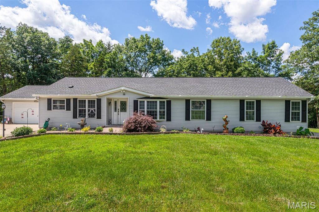 Tucked away on 5.23 wooded acres, this private retreat offers the space, serenity, and flexibility you’ve been searching for. With over 2,000 square feet, 4 bedrooms, and 2 full baths, this beautifully maintained manufactured home delivers comfortable, move-in ready living in a peaceful, secluded setting.  Step inside to a spacious, functional layout featuring a separate dining room and a welcoming living area with French doors that open to a stunning 600 sq ft cedar-lined sunroom—an ideal space to unwind while taking in the surrounding nature and frequent wildlife.  Thoughtful updates provide peace of mind, including luxury vinyl plank flooring (2023), new carpet in all bedrooms (2024), a new roof (2024), and a new refrigerator (2023), along with an HVAC system approximately 6 years old.  Outside, the property truly shines. The expansive, tree-lined acreage offers privacy and room to spread out, while the impressive 30x40 pole barn with loft space easily accommodates a boat or RV and includes a dedicated workshop area. An additional 10-ft carport provides even more covered storage.  Despite its secluded feel, this property is conveniently located just minutes from the highway, parks, shopping, dining, recreational opportunities, local fishing spots, a nearby boat ramp, and Crystal Highlands Golf Course.  Space, privacy, and practical updates—this is a rare opportunity to enjoy both seclusion and convenience in one property.
