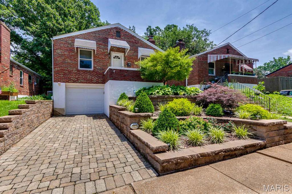 WOW! Just when you thought every attainable, well-maintained, and updated home was out of reach, this charming 3-bedroom, 1-bath bungalow on a great street in Dogtown delivers!

The lush landscaping in the front terrace garden was thoughtfully designed to provide year-round curb appeal with minimal maintenance. Step inside this brick beauty and you'll immediately appreciate the gleaming hardwood floors, freshly painted neutral interior, and cozy wood-burning fireplace in the living room.

The dining area offers flexibility for both everyday meals and special occasions, or it can easily serve as an extension of the living space. Three generously sized bedrooms feature abundant natural light, vinyl windows, and overhead lighting with ceiling fans.

The bathroom is quintessential St. Louis bungalow charm, showcasing timeless black-and-white hex mosaic tile flooring—a classic design element that perfectly complements the home's 1940s character. An updated pedestal sink provides a sleek aesthetic, while the linen closet offers convenient storage for everyday essentials.

The efficient U-shaped kitchen boasts generous prep space, beveled-edge countertops, and an easy workflow. A brand-new microwave and electric range with a stylish slate finish provide both an upscale look and the practical benefit of hiding fingerprints. The oak cabinetry has also been professionally refreshed and updated with sleek new hardware.

Step outside to discover a large, flat backyard featuring both a deck—perfect for summer grilling and al fresco dining—and a charming brick walkway leading to a fire pit, ideal for enjoying crisp fall evenings. In the rear corners of the yard, you'll find a storage shed and raised garden beds ready for vegetables, herbs, or flowers.

The basement is clean and dry, making the storage and laundry areas both functional and inviting. A tuck-under garage provides convenient access to the home.

Several major updates have already been completed, including the roof (8 years old), HVAC system (3 years old), and refrigerator and dishwasher (2 years old).

Don't wait—this home's exceptional condition, thoughtful updates, and attractive price point make it a smart choice for today's buyer.