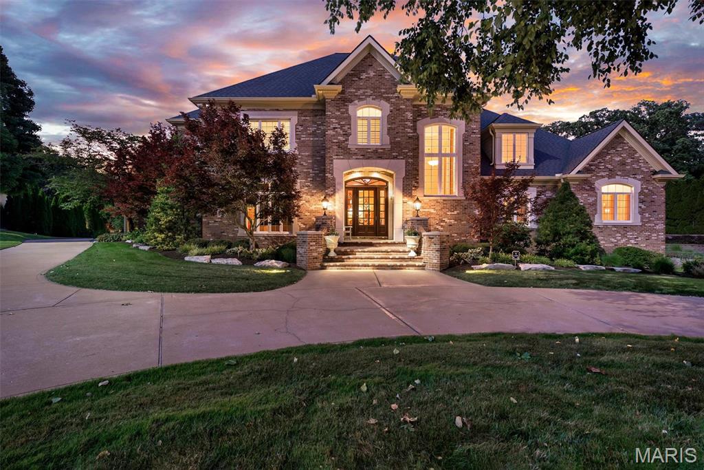 This magnificent custom-built estate delivers 6,223 square feet of refined living above grade — and an impressive 8,828 square feet of total finished living area including the walk-out lower level and is set on a beautifully landscaped 1.08-acre lot in coveted Sunset Ridge. Located within the acclaimed Lindbergh School District, this is a rare opportunity to own a home of exceptional caliber and condition.

From the moment you arrive via the extra-wide circular drive, the home makes a statement: a timeless brick-and-stone exterior, a soaring two-story foyer, and craftsmanship you rarely find. Exceptional millwork, wrought-iron staircases, custom bookcases, and ten + foot tall ceilings on the main level set a tone of understated grandeur throughout.

The gourmet kitchen is a chef's dream — rich cherry cabinetry, granite countertops, dual sinks, two dishwashers, two refrigerators, double ovens, gas cook-top, warming drawer, ice maker, wine cooler, and a built-in desk. It opens to a light-filled hearth room and breakfast area, while the formal dining room comfortably seats 8+. The dramatic two-story great room is anchored by an ornate fireplace and framed by a wall of windows overlooking the pool and spectacular outdoor living spaces.

The main-floor primary suite is a private retreat with a fireplace, spa-like bath featuring heated floors, and two large closets with custom closet systems. A spacious study with fireplace completes the primary suite wing. Upstairs, nine-foot ceilings continue across three generous bedrooms, a sitting room, and three full baths, walk-in closets and custom built-in shelving throughout.

The finished walk-out lower level is built for entertaining: a spacious family room, game room, full wet bar with granite, dishwasher, refrigerator and ice maker, full bath, changing room, and a dedicated home gym with rubberized flooring, plus a built-in entertainment center — and additional unfinished space awaiting your vision.

Outdoor living here is truly extraordinary. A beautiful covered Lanai overlooks the grounds, while a spacious poolside cabana features a wood-burning fireplace and large-screen TV — the ultimate setting for entertaining beside the private, in-ground saltwater pool and spa (2025). An outdoor kitchen, professional landscaping, accent lighting, full irrigation, and a fenced yard complete this private resort.

Impeccably maintained and thoughtfully updated: roof (2025), Pella front windows, refreshed interior and hardwood floors, four 200-amp electrical panels with surge protection, updated garage doors, epoxy garage flooring (2026), a primary closet system, primary-suite and study carpet (2026). Four HVAC zones, central vacuum, an owned security system with eight exterior cameras, a whole-home sound system, and five fireplaces round out an extensive feature list.

A three-car attached garage, butler's pantry, and main-level laundry add everyday function to the luxury — all within an established Sunset Hills neighborhood, just minutes from highways, shopping, dining, and parks. Homes of this caliber rarely become available. Schedule your private showing today.