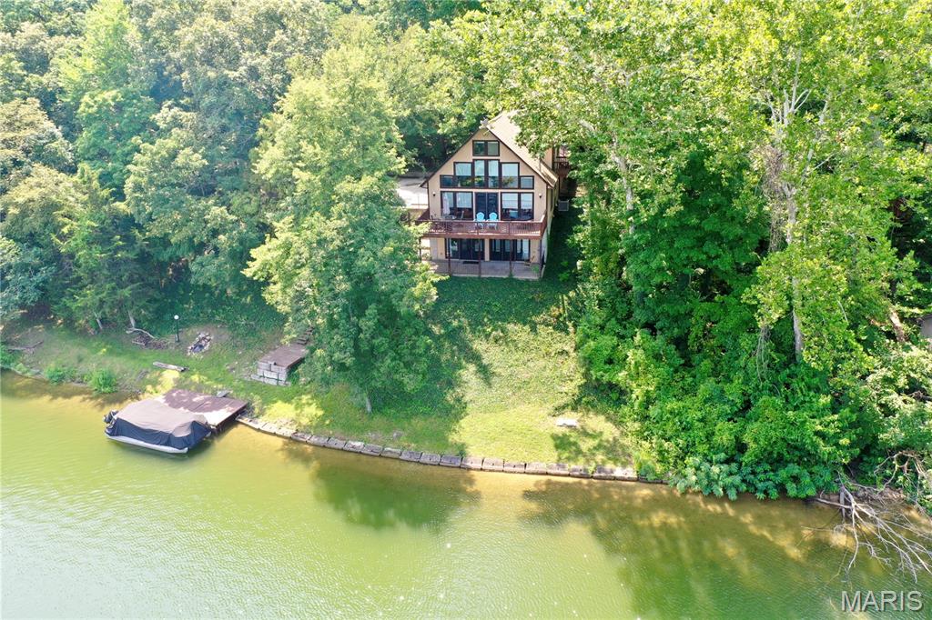 This lakefront home in Pinnacle Lake Estates offers a warm, inviting blend of comfort, updates, and peaceful water views. The upper level features a private bedroom retreat with a full bath and a relaxing deck perfect for quiet mornings with coffee. On the main level, an updated kitchen, refreshed lighting, and new flooring complement the cozy wood-burning stove and a second full bedroom and bath. The walkout basement adds even more living space with a guest sleeping area, an electric fireplace, and patio doors leading to a large, covered patio complete with a swing—an ideal spot to enjoy the lake breeze. A spacious deck connects the outdoor spaces, creating easy flow for gatherings. The property also includes a two-car garage, sits just past the dam, and comes with a dock and a negotiable boat, making lake living effortless and enjoyable.