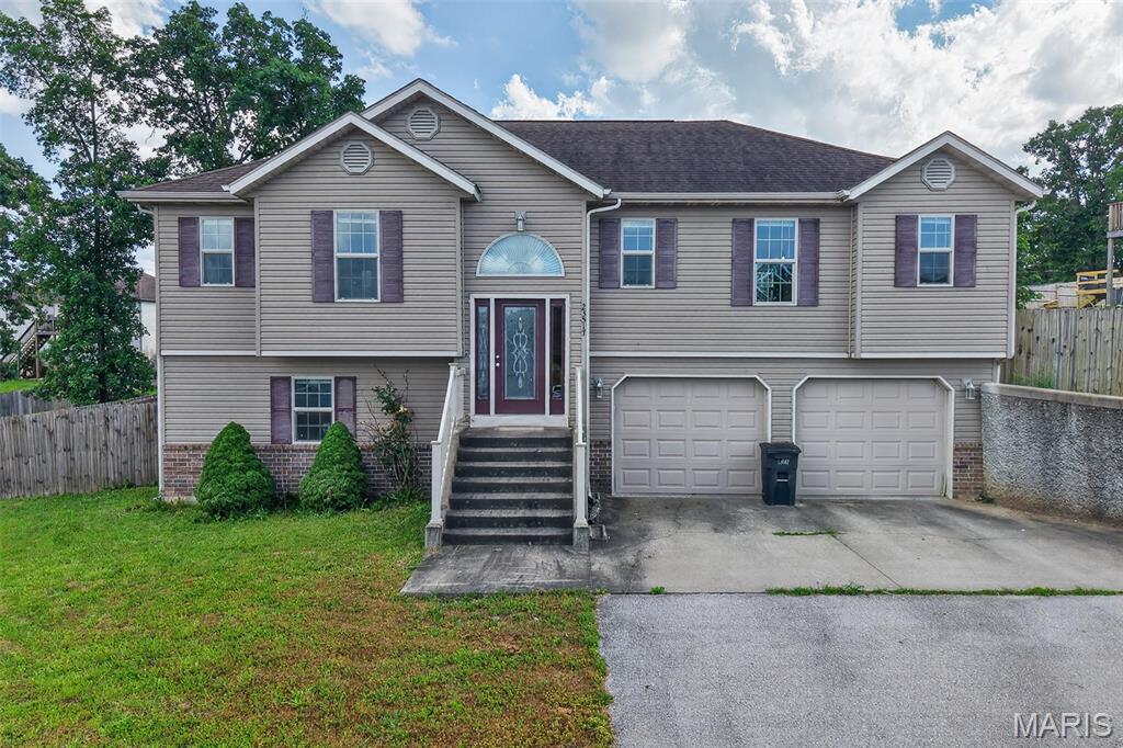 Step into your dream home in the heart of Taylor Hills! Just minutes from Fort Leonard Wood and very close to the new Waynesville elementary school. This spacious split-foyer beauty offers the perfect blend of style, comfort, and functionality. Sunlight floods the open-concept main living area, highlighting the warm wood floors and creating an inviting space for everyday living and entertaining. The large kitchen, featuring a cleverly hidden walk-in pantry, is ready for all of your culinary adventures. Also on the upper level are three spacious bedrooms and two full bathrooms to provide a private retreat for family and guests. The partially finished walk-out basement adds a fourth bedroom, third full bathroom, laundry area, and a versatile family room—ideal for movie nights, playtime, or a cozy reading nook.

Car enthusiasts and hobbyists will love the oversized 23'x25' garage with extra storage space. Outside, a mostly flat, fully fenced backyard and a freshly updated deck create the ultimate setting for summer barbecues, gardening, or simply relaxing in peace and privacy.

This Taylor Hills home isn’t just a place to live—it’s a lifestyle waiting to be enjoyed!
 Square footage and measurements are approximate REF DSC-8001.