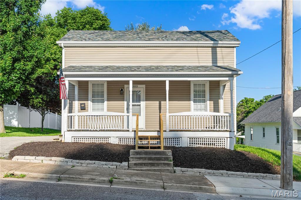 Looking for a New Place to Hang Your Hat?  Here It Is!  Step up on the big covered front porch and into this great house and you will be delighted.  As you enter you'll find the living room to your left and dining room to the right, both sporting gleaming wood flooring.  Kitchen has been nicely updated and offers plenty of natural light.  Main floor laundry is located just off the kitchen and walks out to deck and fenced back yard.  Full bath rounds out the main floor.  Two bedrooms are housed on the upper level along with second full bath and hall closet for storage.  Soft neutral color palette throughout to compliment any decor.  Don't forget the oversized, detached garage.  New roof and gutters, 2026.  Come and see for yourself before it's too late!