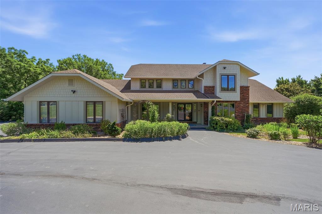 Perched on 3 beautiful acres in the sought-after Old Manchester area of St. Louis County, this 1.5-story home offers the kind of views that are hard to find and impossible to forget. Tucked away on a quiet private lane with only a handful of neighboring homes, you'll enjoy the perfect combination of privacy, peaceful surroundings, and convenience.

Designed for both everyday living and entertaining, the main level features an open floor plan with a sunken living room, spacious dining room, and a great room anchored by a striking wood-burning fireplace. A built-in wet bar with an icemaker, wine and beverage refrigerators, and surround sound system makes hosting effortless. Two separate four-season rooms span the back of the home, showcasing panoramic views through oversized picture windows and offering heated tile floors and dedicated heating and cooling systems for year-round comfort.

The updated kitchen is the heart of the home, featuring a large center island with prep sink, JennAir range, double wall ovens, abundant cabinetry, and excellent space for gathering.

The primary suite offers a private retreat with a spa-like, updated bathroom featuring heated floors, a steam shower, jetted tub, skylight, abundant storage, and a spacious walk-in closet. Upstairs you'll find three additional bedrooms, including a secondary suite with its own updated private bath, as well as an updated hall bath.

The finished walkout lower level provides even more living space with a billiards area, wet bar, entertainment space, office with custom built-ins, craft room with a private exterior entrance, updated bath, generous storage, and a second wood-burning fireplace that adds warmth and character.

Step outside and you'll quickly understand why the current owners consider this their personal retreat. An expansive deck system spans the entire back of the home, with open decking flanking both sides of the two adjoining four-season rooms. Multiple staircases provide easy backyard access from both ends, creating seamless indoor-outdoor living and exceptional flow for entertaining. Below, a covered decorative concrete patio offers a shaded outdoor living space perfect for relaxing. The property also features a fenced backyard, separate fenced pet area, fire pit area, and a detached 16'x24' building with electric service.

Beyond its incredible setting and living spaces, this home has been extensively updated and meticulously maintained. Recent improvements include a new well and septic system (2025), Hardie siding (2024), select updated Pella windows, new remote-controlled blinds, a new sliding glass door in the walkout lower level, and new gutters. A Kohler whole-house generator, three-zone HVAC system, 33-zone irrigation system, Spectrum fiber internet, security system, 3-car garage, and circular driveway complete this exceptional property.

If you've been searching for privacy, breathtaking views, and space to enjoy both indoors and out, this is a home you truly need to experience in person.