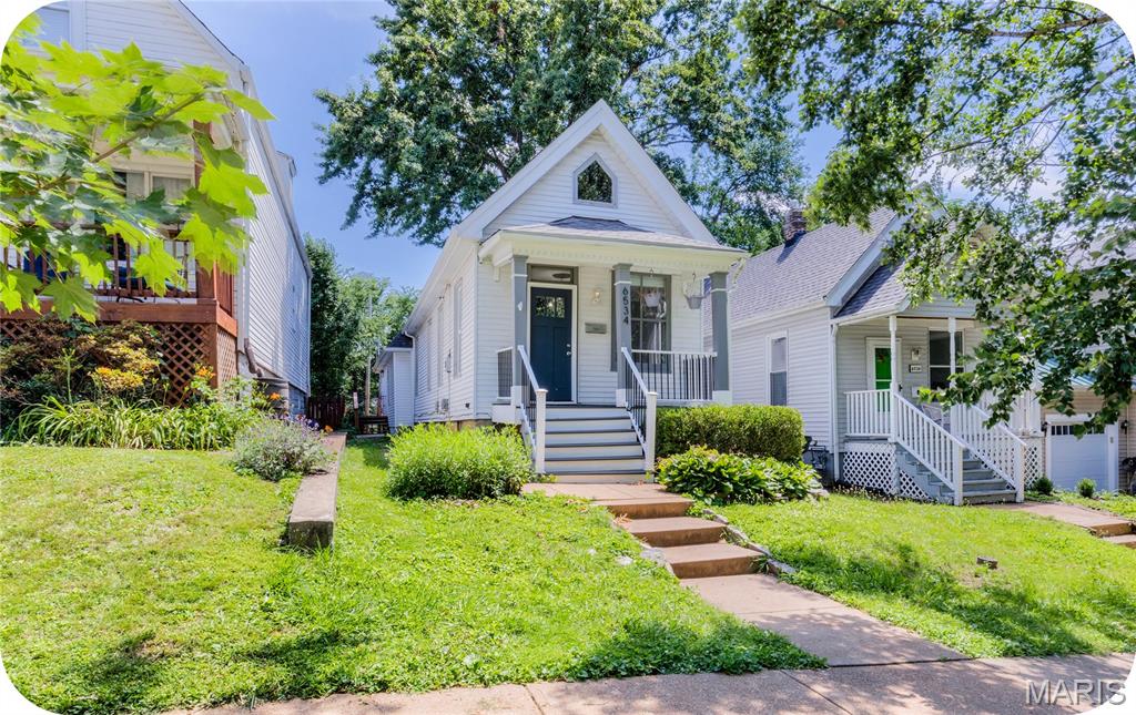 This adorable and surprisingly spacious Dogtown bungalow is located in an unbeatable location! Just steps from neighborhood favorites including Seamus McDaniel's, Tamm Avenue Bar, Felix's Pizza Pub, Stone Turtle, and Hogtown Smokehouse, plus only minutes from Forest Park, the Saint Louis Zoo, and convenient access to both Hwy 40/64 and I-44. This charming home started as a classic Dogtown shotgun bungalow and has been thoughtfully expanded to nearly double its original size, creating a layout that lives much larger than you'd expect. The inviting front porch welcomes you inside to an open-concept living and kitchen area featuring white cabinetry, stone countertops, stainless steel appliances, and plenty of space to gather. The addition includes a primary bedroom with great closet space, two additional bedrooms that are perfect for home offices or hobby spaces, and a beautifully updated full bath with double sinks, a separate soaking tub, and walk-in shower. The finished lower level adds even more flexibility with an additional living area and a second full bathroom. Outside, enjoy a low-maintenance backyard complete with a back deck for relaxing or entertaining, plus a detached one-car garage. Cute, easy to maintain, and packed with character, this Dogtown gem offers the perfect blend of neighborhood charm, modern updates, and everyday convenience.