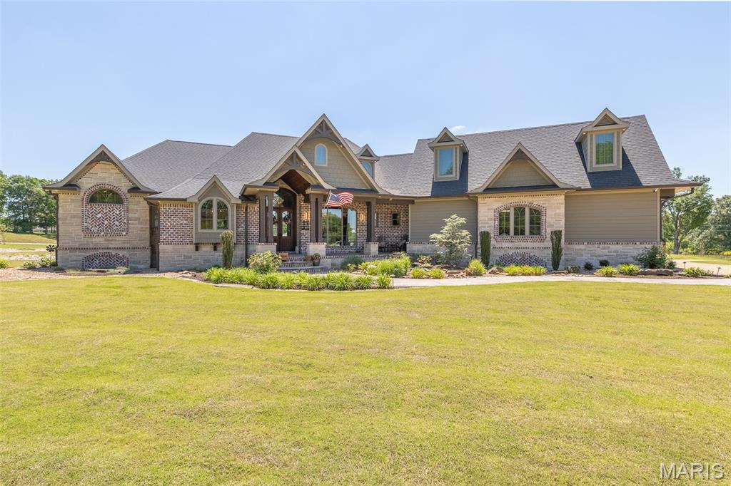 Welcome to a property that redefines luxury living. This extraordinary 5,678 +/- sq ft estate was masterfully designed with intention, craftsmanship, and unforgettable detail at every turn. From the moment you step inside, you're greeted by soaring ceilings, stunning architectural beams, rich custom finishes, and panoramic views overlooking a stocked pond. The primary suite is a truly private retreat- featuring intricate ceiling detail, an oversized layout, deck access, heated bathroom flooring, and an incredible walk-in closet complete with its own laundry area for ultimate convenience. The chef's kitchen is nothing short of spectacular with industrial-grade appliances, double ovens with warming drawer, a hidden baker's pantry, and an impressive layout made for entertaining and everyday luxury alike. Thoughtfully designed for both comfort and functionality, the home also offers an oversized 3 car garage, additional laundry & mud room, true executive office, a safe room PLUS wine room, and even additional large family room with more views. Step outside and experience resort style living with an outdoor kitchen, expansive patio spaces, back porch with fireplace, and serene water features surrounding both the front and back of the home. Every inch of this property was curated to an unforgettable experience. This is more than a home- it's a statement piece you truly have to see in person to appreciate.