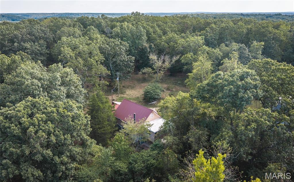 Privacy, nature, and room to breathe, at the end of the road. This 4 bedroom, 3 bath home sits on 1.8 +/- mostly wooded acres with only a few neighbors and plenty of room to explore. An open, sunny area is ready for your garden. Located off Hwy 8 just outside Steelville, you're minutes from Huzzah Valley and the Huzzah Creek for floating, fishing, and weekends outdoors.
The main level offers a spacious open floor plan centered on a wood-burning fireplace, two bedrooms, and a remodeled bath. Upstairs you'll find two more bedrooms and an updated shared bath. The walkout lower level gives you flexible space for a home office, gym, game room, or hobby space. It opens to a very large patio that's ideal for entertaining or for screening in or enclosing to add living space.
Move-in ready and tucked into the woods, this is the kind of Ozarks home buyers wait for. Schedule your showing today.