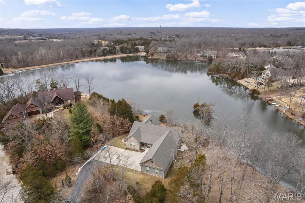 This stunning 6-year-old Innsbrook Resort home offers 170 feet of waterfront and the perfect blend of luxury and relaxation. Designed for both weekend getaways and full-time living, the home features 4 bedrooms, a home office, and a yoga room—both of which can serve as additional sleeping spaces. The home boasts a geothermal HVAC system, 9-ft ceilings, and a gourmet kitchen with a Jennair induction cooktop, convection oven, walk-in pantry with sink, and pass-thru window to the patio. Thoughtful details include electric blinds, two fireplaces, and a serene primary suite with dual walk-in closets and an outlet-equipped vanity drawer. Enjoy two laundry rooms, a mudroom with a cedar closet, a three-car garage with built-in organization, and a versatile craft/exercise room. A lower-level office and guest suite with a full bath add flexibility. Outside, a private dock, underground dog fence, and ample parking complete this lakeside retreat, perfect for weekend escapes or year-round living. Additional Rooms: Sun Room