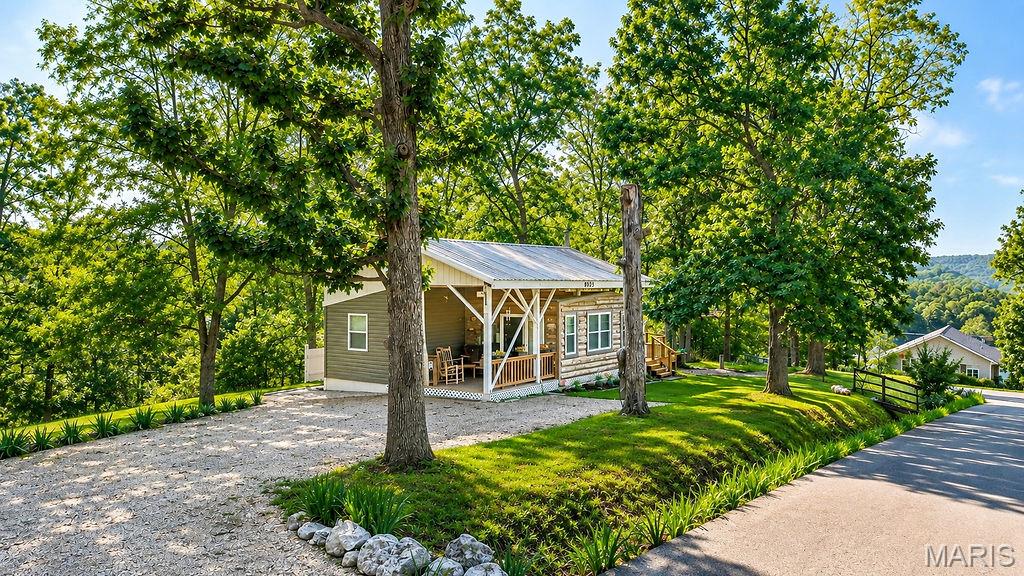 Lake life is calling! This adorable newer-construction addition to a cozy cabin-style home sits on three lots in a corner, lake-view location and offers so much opportunity to enjoy the best of lake living. With approximately 900 square feet of unique features living space, this property features two bedrooms, one full bath, an open kitchen and living area, and a wood-burning stove that adds the perfect cozy touch.

But the real magic happens outside! Enjoy your morning coffee or evening gatherings from the front porch or newer back deck, where you can relax and watch the boats go by. The property also offers an RV hookup, plenty of parking, fire pit, treehouse, and open grassy area—perfect for kids to play or for entertaining family and friends.

Need room for all your lake toys? You’ll love the 20 x 27 outbuilding/garage shop, offering plenty of space for a boat, side-by-sides, RZRs, lake gear, and more.

Whether you’re looking for a weekend getaway, a lake retreat, or a place to make your own, this property offers endless possibilities. Cozy, comfortable, and packed with outdoor enjoyment, just bring yourselves and start living the lake life! Who’s ready to make it their own?
