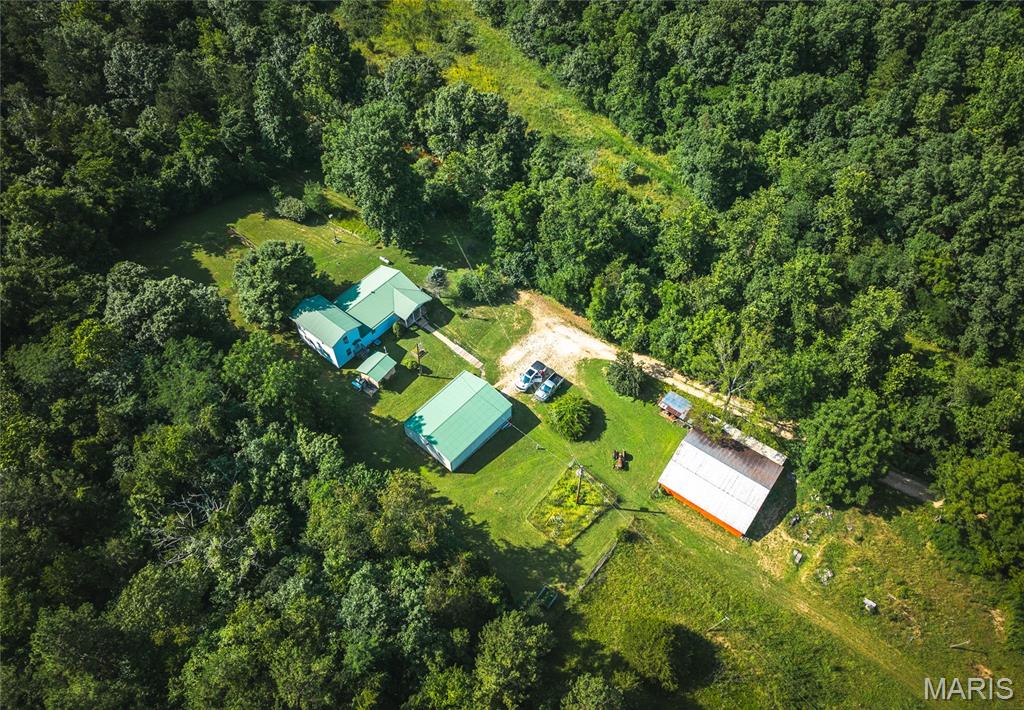 This incredible 155-acre property is a true Ozark treasure—featuring a spring-fed, crystal-clear creek that winds through a landscape rich with mature white oak, black oak, and red oak timber. The land boasts rolling hills, scenic ridgelines, and a mix of open ground ideal for food plots, making it a hunter’s paradise. Deer, turkey, and even the occasional hog roam freely through this area, and if 155 acres isn’t enough, this tract borders the Mark Twain National Forest on two sides, giving you direct access to over 75,000 acres of public land to hunt, hike, and explore. The 4-bedroom, 2-bath home offers comfort and space for a full-time residence or the perfect weekend escape, just 2.5 hours from St. Louis and minutes from the town of Viburnum for shopping and supplies. A pole barn with electric and concrete floors provides excellent storage for tractors and equipment, while a second, older wooden barn adds that classic farm charm and could be used for livestock, hay, or extra storage. Whether you're looking for a secluded hunting base, a homestead in nature, or a weekend getaway with unmatched access to wilderness, this property checks all the boxes.