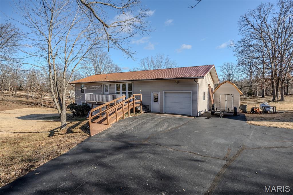 Welcome to this solid and well-maintained walkout basement home in Linn Creek, offering over 2,600 square feet of comfortable living space. With four bedrooms—including a non-conforming bedroom in the basement—and two full bathrooms, the layout provides exceptional flexibility for multi-generational living, guests, or entertaining. Both the main level and lower level feature full kitchens, complemented by two separate living areas, creating ideal spaces for hosting or extended stays. The walkout basement also includes a fully enclosed sunroom, perfect for relaxing year-round while enjoying the peaceful surroundings. The home has been well cared for over the years and offers a strong foundation, while still allowing a new owner the opportunity to make cosmetic updates and add personal touches over time. A one-car attached garage, generous room sizes, and a convenient location near the Lake of the Ozarks round out this versatile and inviting property in Linn Creek.