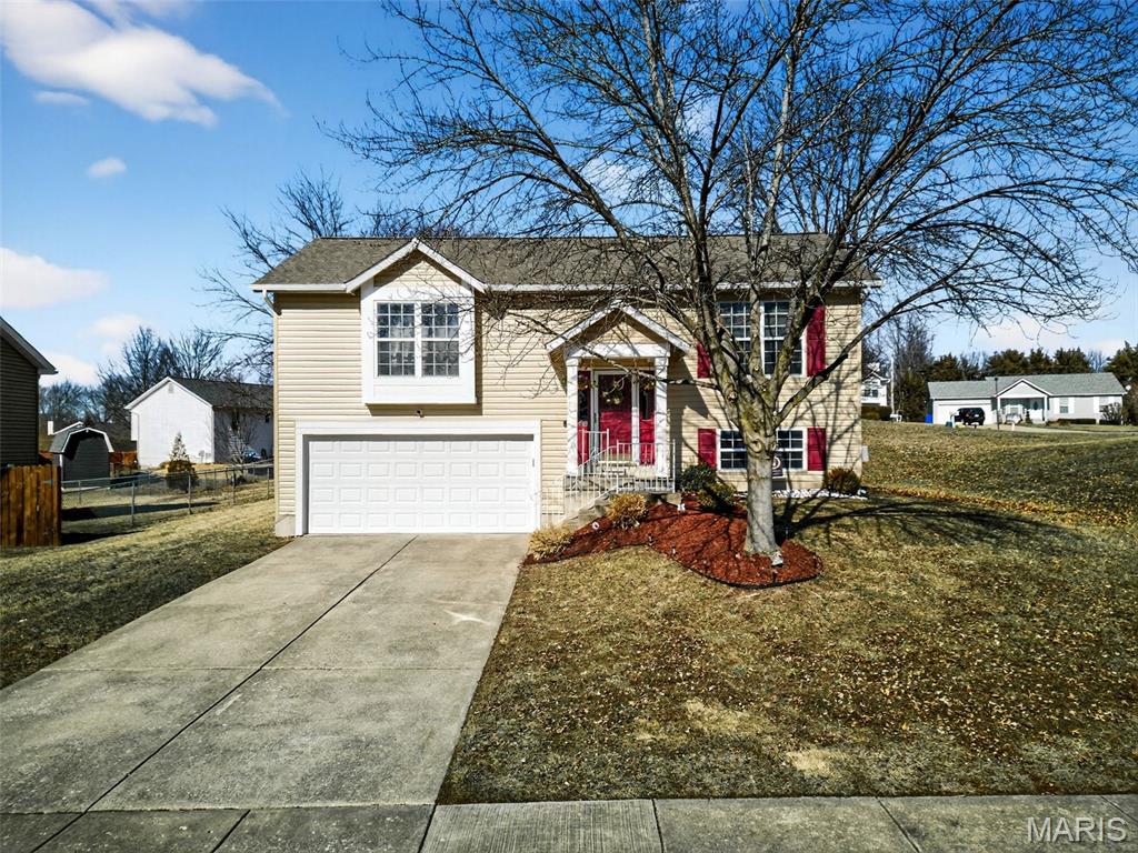 Welcome home to this beautifully updated 3-bedroom, 2 full bath multi-level home in Wentzville, conveniently located just minutes from Interstate 70 and U.S. Route 40/61 for easy commuting and access to shopping, dining, and schools. Step inside to a bright, open floorplan featuring a vaulted ceiling in the spacious great room. The living room flows seamlessly into the dining area and kitchen, creating the perfect space for everyday living and entertaining. The kitchen opens to a large maintenance-free deck overlooking the level backyard — ideal for summer gatherings and relaxing evenings. The main level offers two comfortable bedrooms and a fully renovated bathroom featuring a new vanity, mirror, toilet, and shower door. Updates throughout the home include LVT flooring, 6-panel doors on the main level, newer light fixtures, ceiling fans, chandeliers, and window screens. The lower level provides even more living space with a generous family room, third bedroom, second fully renovated bathroom, laundry room, and convenient under-stair storage. An oversized 2-car garage completes the lower level. Major updates include a newer roof, hot water heater, renovated front concrete steps, newer appliances (washer, refrigerator, stove, dishwasher), and more — giving you peace of mind and modern comfort. Situated on a level lot in a quiet neighborhood, this move-in ready home offers space, style, and convenience in one fantastic package.