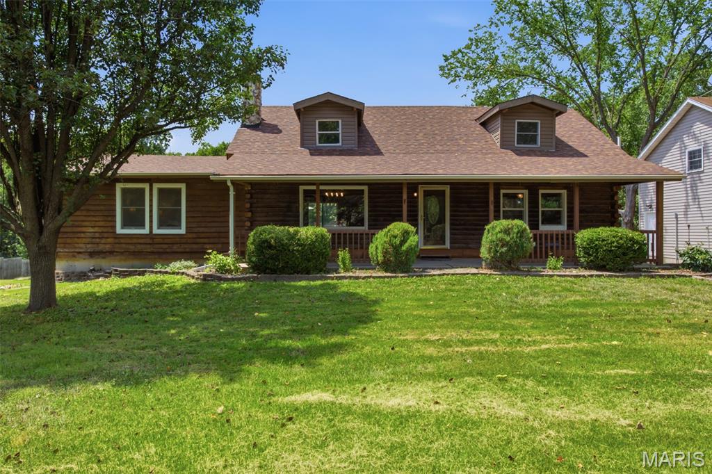 Welcome to this stunning story-and-a-half log cabin nestled on 4 picturesque, partially wooded acres, offering the perfect blend of rustic charm, modern updates, and endless possibilities. This spacious property features 4 bedrooms, 3 full baths, plus a beautifully finished 582-square-foot studio apartment/ADU above the detached garage.
The versatile studio apartment is ideal for short-term rental income, a full-time rental, guest suite, multigenerational living, home office, art studio, or recreation space. It includes a full kitchen with quartz countertops, stainless steel appliances, a center island with seating, refrigerator, an updated full bath with a tiled shower, laundry hookups, and a one-year-old mini-split HVAC system. Inside the main home, you'll find a beautifully updated kitchen featuring quartz countertops, stainless steel appliances, soft close wood cabinets and an open layout that flows seamlessly into the dining area. Hardwood floors extend throughout the home, while the inviting great room offers a cozy fireplace. The spacious main-floor primary suite includes a renovated en-suite bath, and an additional full bath on the main level provides convenience for guests. Upstairs, a new staircase leads to three additional bedrooms and a remodeled full bath. The walk-out basement offers abundant storage and future living space, complete with a rough-in for an additional bathroom. Major updates provide peace of mind, including newer HVAC systems, hot water heaters, roof, deck, vinyl siding, and gutters on all three buildings. The front two acres feature the home, beautifully landscaped yard, mature trees, a large fire pit, a 20-foot flagpole, and two detached two-car garages with ample parking and workspace. The additional two wooded acres behind the backyard offer exceptional privacy and opportunities for hunting, hiking, or simply enjoying nature. Located in unincorporated Troy with no subdivision restrictions or HOA, this property borders Cuivre River State Park along the left side and rear property line, creating an unmatched natural setting. Additional features include a paved road frontage, large concrete driveway, a 23' x 25' detached garage with the studio apartment above, and a second 30' x 23' detached garage. An in-ground pool is also located on the property. It has been emptied and painted and is being sold AS-IS, as the seller is unaware of its current condition. If you've been searching for peaceful country living with modern updates, flexible living spaces, and room to roam, this one-of-a-kind property is ready to welcome you home. Property is agent owned.