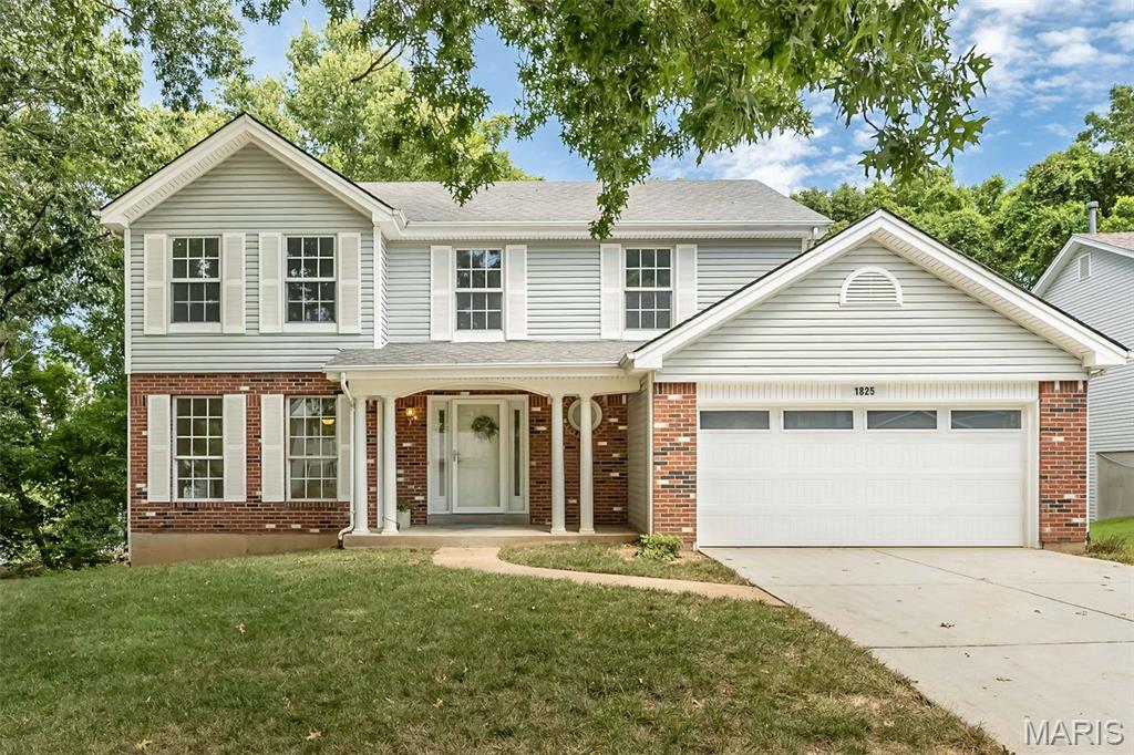 Welcome home to this spacious 4-bedroom, 2.5-bath two-story offering a wonderful combination of comfortable living space, thoughtful updates and a beautiful wooded setting in the AAA Rockwood School District. Great curb appeal with professional landscaping and covered front porch welcome you inside.  Engineered hardwood flooring runs through the main floor, while newer carpet in the upstairs bedrooms and stairs.  The updated kitchen is the heart of the home, featuring rich wood custom cabinetry, generous stone counter space, stainless steel appliances, butler's pantry and center island. Large windows and newer glass slider door bring in abundant natural light while providing peaceful views of the surrounding trees. The kitchen and breakfast area opens conveniently to the adjoining living areas, creating an easy flow for everyday living into the spacious family room with a wall of windows and a classic woodburning fireplace. Formal living room, dining room, laundry and half bath complete the main floor.  Upstairs, you'll find four generous size bedrooms, including a primary suite with a private bath featuring a double vanity, separate shower and freestanding soaking tub.  One of the home's biggest opportunities is the large unfinished walk-out lower level with roughed-in plumbing, offering excellent potential for future additional living space, a recreation room, home office, gym or guest area while still providing plenty of storage.  Outside, enjoy a private, tree-lined backyard setting with a deck overlooking the natural surroundings. An attached two-car garage, attractive brick and siding exterior and convenient location complete the package.