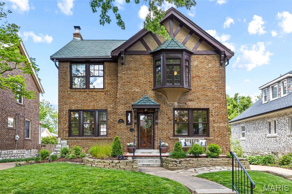 Quintessential charm meets modern luxury on one of the most sought-after tree-lined streets in University City. Located at 7411 Teasdale Ave., this stately Tudor home blends classic architectural character with impeccable high-end finishes in nearly 2,600 square feet of living space. The curb appeal is undeniable. From the moment you enter, the arched entryways, stained glass windows, and refinished wood floors will captivate you. The living room features a stunning arched fireplace and custom built-ins with visual comfort lighting, a hidden dry bar and desk area. The spacious dining room flows into the beautifully updated kitchen, complete with quartz countertops, a farmhouse sink, soft-close white cabinetry and  Pro gas range. A bonus main floor laundry room sits adjacent to the powder room, while the mudroom/office area’s windows overlook the maintenance-free deck and backyard. Upstairs, you will find three generously sized bedrooms and a fully remodeled bathroom featuring dual sinks, high-end finishes, and a clawfoot tub. The lower level offers its own speakeasy-inspired retreat with moody dark tones and cozy vibes – perfect for entertaining or relaxing. Outside, enjoy the new, oversized two car garage, a dedicated dog run, and a fully fenced yard with a custom gate. Additional features include Marvin thermal wood windows, a new roof, and a new HVAC system. This unbeatable location is walkable to both University City and Clayton's best parks, shops, and dining – without the Clayton price tag. A rare blend of character and modern living, this home is truly one of a kind.