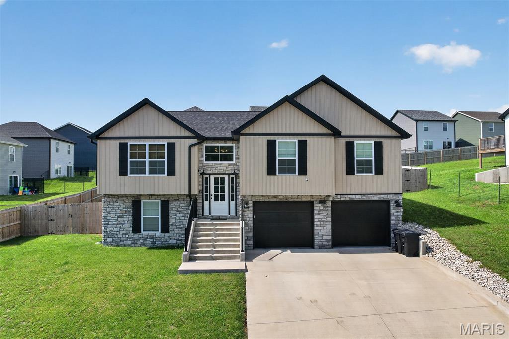 An absolute beauty!  This 4 bedroom, 3 bathroom split foyer home features a privacy fenced back yard and upgrades throughout! This home is located within the city limits of Waynesville, in the Waynesville School District and is just a short drive to Fort Leonard Wood. The upper level shows a beautiful open concept floor plan with vinyl plank flooring, vaulted ceiling, & custom light fixtures. In the kitchen area you will find all stainless appliances, quartz countertops, center island, custom cabinetry and more. Also upstairs is the primary bedroom suite with an impressive walk in closet. Primary bathroom showcases an oversized soaking tub, glass enclosed tiled shower and double vanity sinks. Two guest bedrooms and a full guest bath are also upstairs just down the hall. Downstairs is the laundry room, a large family room, full guest bathroom and a 4th bedroom. Other great features include a two car garage, deck patio area and ADT security system.  Call today to schedule your showing!