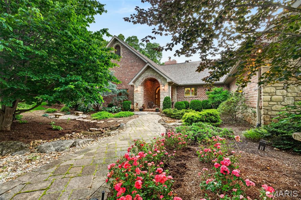 NOW OFFERED AT A NEW PRICE! This stunning custom-built ranch sits on 3 private, wooded acres and lives like a secluded retreat. Extensive landscaping and uninterrupted views surround the home, creating unmatched serenity and beauty from the moment you arrive.
*Inside, over 5,100 sq. ft. of refined living space features a soaring great room with hardwood floors, dramatic masonry fireplace, large windows that frame the landscape, and skylights fill the home with soft, natural light. The beautiful wood domed ceiling and wall of windows create a picture-perfect dining experience, with nature providing the backdrop. The gourmet kitchen includes Wolf appliances featuring a sub-zero refrigerator, gas cooktop and double ovens. Spacious walk-in pantry, sleek countertops and butterfly breakfast bar complete the kitchen area. Wake each morning to the serene views from the main floor primary bedroom that is both generously sized and offers a cozy reading alcove. Spa-like bath and expansive closet space complete the suite. Two additional bedrooms, a full bath, guest 1/2 bath, laundry room and utility room with additional half bath complete the main level.
*A covered patio expands the main-level living outdoors, ideal for relaxing, outdoor dining or hosting while overlooking the lush gardens. 
*The finished lower level extends your living and entertaining options with a spacious family room, a 2nd cozy fireplace, recreation area, stone bar, media/exercise area, full bath and 4th bedroom—plus bonus space perfect for a wine cellar/hunting closet/safe room. Walk out to the stone patios and enjoy quiet evenings surrounded by nature. Flagstone steps lead down to the 30x50 fenced vegetable garden- awaiting plantings of your choice.
*Additional highlights include a 3-car oversized side-entry garage with workspace, dual geothermal heating and cooling systems and irrigation system. 
* Private, tranquil, and beautifully designed—this is more than a residence-it's a destination.  Tucked away in the heart of wine country and only 15–20 minutes from I-70, it offers the perfect balance of feeling worlds apart while still being easily accessible. Make this quiet haven your home today!