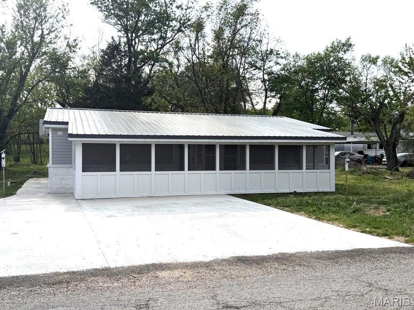 High-Tech Comfort Meets Small Town Charm in Mountain View, Missouri Welcome to a home where no detail was spared. This 3-bedroom, 2-bath masterpiece from the new metal roof and spray-foam insulation (interior/exterior walls foamed and attic is rockwool insulation) to the high-end finishes, this home offers the peace of mind of new construction. Step into an inviting living room featuring a built-in electric fireplace and integrated surround sound that extends through the kitchen and out to the screened porches. For the remote worker or gamer, every room is hardwired with network cables for seamless connectivity. Climate control is effortless and efficient with individual mini splits throughout the home for personalized comfort. The master suite is a true sanctuary. It features a spacious walk-through closet with new carpet leading into a spa-like bathroom. Enjoy the luxury of Heated floors and heated towel racks, Double sinks with defogging mirrors, A large soaking tub and separate walk-in shower. The kitchen is a focal point, boasting a butcher block island with extra outlets, rock tile backsplash, and brand-new electric appliances, stove and dishwasher. Beyond the kitchen, discover the ''hidden'' laundry room--a functional dream with a butcher block folding table, oversized storage cabinets, and the home's mechanical hub, including an on-demand water heater, water softener, and an emergency water manifold system. The pantry space features even more butcher-block counters, extensive cabinetry, and dedicated room for a refrigerator and meat freezer. The two additional bedrooms feature new carpet and closets equipped with motion-sensor lighting for ultimate convenience. Enjoy the outdoors from your choice of two screened-in porches (front and back). The property sits on a generous 150x74 lot and is completed by a brand-new concrete driveway and matching walkways into either the front/back screened in porches.
