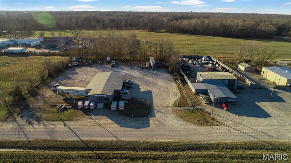 Looking for turnkey commercial space close to highway 60 and future Interstate 57, how about 2 business locations!  This one consists of trucking, towing, and mechanics dream business layout with 3 different red iron buildings built together over 4300 square foot with hanging lights, heaters, and winch spots.  Concrete floors and 6 roll up and through doors with big truck clearance.  There is also estimated 500 square foot office or retail with large office, front room, bathroom, and wash area with central electric heat and air.  Also to boot, attached lean-to lunch or party area private around the shop for cookouts or outside work.  This business sits of .88 acres.
Then comes the 2nd building.  The office area has been recently renovated, just needs paint and your business touch.  There is large entry room one private office and bath in this heated and cooled estimated 400 square foot. Connected to warehouse and storage building just holding toys with high ceilings and another red iron building,  Total square foot on this building is 3100 square foot with 8 large rolling doors to loading docks mostly all with covered entrances.  Large open gravel lot for big truck turn around and 50 Amp connects in the back of 2.12 acres, totaling both property sided by side with separate security and privacy fence on 3 acres.