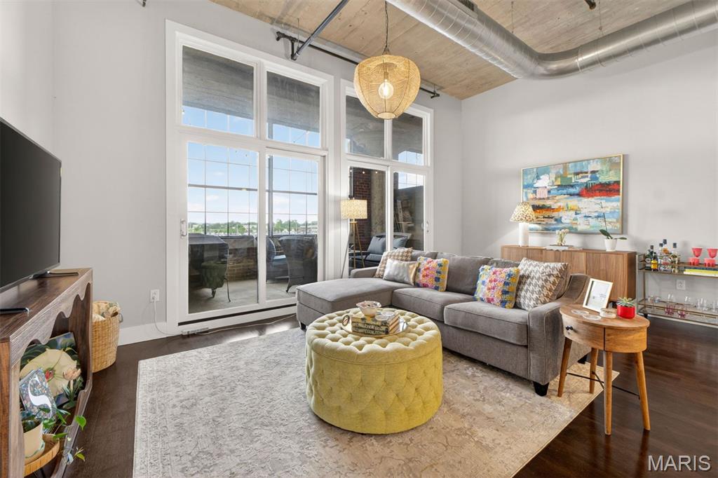 Experience elevated city living at West End Lofts in this stylish contemporary condo featuring soaring ceilings and designer finishes throughout, including wood floors, granite countertops, Italian cabinetry, and upgraded lighting and fixtures. The open-concept layout offers a bright living and dining space that flows seamlessly to a private screened porch with gas hookup for grilling—Blackstone included—perfect for relaxing or entertaining. The spacious kitchen with stainless steel appliances proudly anchors the living area. Retreat to the oversized primary suite with a large walk-in closet and spa-inspired bath complete with dual vanities, updated countertops, glass-enclosed tub/shower, and separate water closet. A versatile den/office, laundry closet (washer/dryer included), and half bath add everyday convenience. Included with the sale are one covered parking space and private storage. Residents enjoy resort-style amenities including an outdoor pool, fitness center, billiards room, guest suite, and secure gated parking. Ideally located in the heart of the Central West End with easy access to restaurants, nightlife, the Cortex Innovation District, BJC Hospital, Washington University Medical School, Saint Louis University, and the trails and green space of Forest Park. Condo fee includes everything but electric. (New AC 2023, dishwasher 2022).