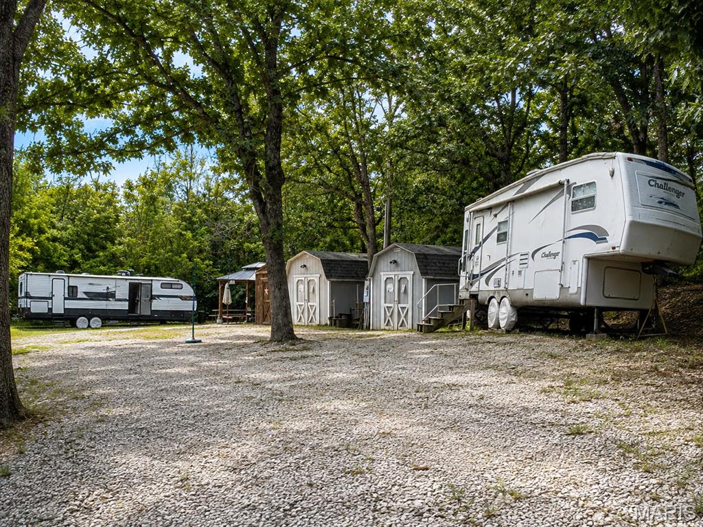 Ready to start making memories at LAKE PERRY? This unique property at 3037 Sugar Maple Ct in Perryville gives you the opportunity to enjoy the lake lifestyle NOW—with plenty of room to bring family and friends along!

Featuring TWO RV/CAMPER HOOKUPS already equipped with WATER, ELECTRIC AND SEWER, you can pull in, get settled and start enjoying weekends at the lake without waiting to build. Invite friends or family to bring their camper and create your own private Lake Perry getaway where mornings are slow, evenings are spent around the fire, and weekends are filled with boating, swimming and time outdoors. TWO STORAGE SHEDS provide plenty of space for lake toys, fishing gear, tools and all the extras that come with lake life. There's even an existing PLATFORM FOR A ZIPLINE, adding another fun possibility to this outdoor retreat.

And when you're ready to venture out, Lake Perry offers so much more! This private gated community surrounds a beautiful 200-ACRE SPRING-FED LAKE where residents enjoy boating, tubing, water skiing, kayaking and fishing. Spend summer afternoons at the SWIMMING POOL or SANDY BEACHES, enjoy volleyball and playgrounds, or meet up with neighbors for community events, food trucks, fishing derbies, trivia nights and holiday celebrations.

Surrounded by wooded serenity near MARK TWAIN NATIONAL FOREST, Lake Perry feels like a true escape while still being just minutes from Perryville. Whether you're looking for a WEEKEND CAMPING RETREAT, RV GETAWAY, gathering place for family and friends, or a property to enjoy now with possibilities for the future, 3037 Sugar Maple is ready for your next chapter at the lake. Pack the camper, bring the lake toys and come see why weekends are just better at Lake Perry! Please ask about the 36 FOOT TRAVEL TRAILER which is also FOR SALE!!
