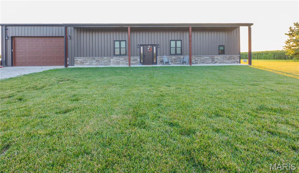Exceptional all-steel home built with a heavy metal beams and approximately 10” of spray foam insulation for outstanding energy efficiency. Features 200-amp electrical service for the home, 100-amp service for the attached 3-car garage, a whole-house generator, tankless water heater, four hard-wired security cameras, commercial-grade metal exterior, zoned in-floor heat with a heat pump, emergency heat strips, and three thermostats for customized comfort. The impressive open-concept great room boasts 14-foot ceilings with modern, exposed ductwork, a large quartz island, and stainless steel appliances. The spacious primary suite offers a large walk-in closet with a hidden safe room featuring 12-inch concrete walls. The luxurious primary bath includes double vanities and an impressive 5’ x 9’ tiled walk-in shower with three shower heads. With five bedrooms plus a bonus room currently used as a playroom (ideal as a sixth bedroom or office), there’s room for everyone. The oversized laundry/mudroom is conveniently located off the attached heated 3-car garage. The 25’ x 50’ heated garage offers a storage loft and two overhead doors for easy access to vehicles, equipment, and toys.