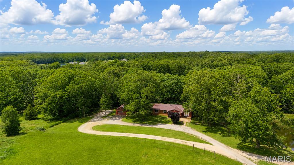 This home and property is an absolute MUST SEE! This property is just shy of 8 acres with a massive 36x60 shop and detached oversized 2-car garage. As soon as you turn into the driveway, the first thing you'll notice is the blacktop paved drive with serene views of your fenced in pastures, well-maintained lawn and beautiful lake views. This full brick home features 4 bedrooms, 2 bathrooms, full finished basement, covered back deck, custom woodwork accents throughout and much much more. Just a couple minutes from town and off a well-maintained state highway. As soon as you step inside, you'll notice the open foyer with custom atrium style island to welcome all of your future visitors, hand crafted stairwell banisters and rails, wood burning fireplace made of all stone, eat-in kitchen with stainless steel appliances and so much more. Downstairs you will find a recreation room, kitchen, tanning room, bedroom and full bath. The shop is partially insulated and features propane heat, 12-foot automatic overhead doors, 1/2 bath and is on its own electric meter and septic to be completely self-contained. This property has too much potential to list. Rather you are looking for the perfect mini farm with a great location or an easy to maintain home with custom features, then this is the home for you. Schedule your showing today!