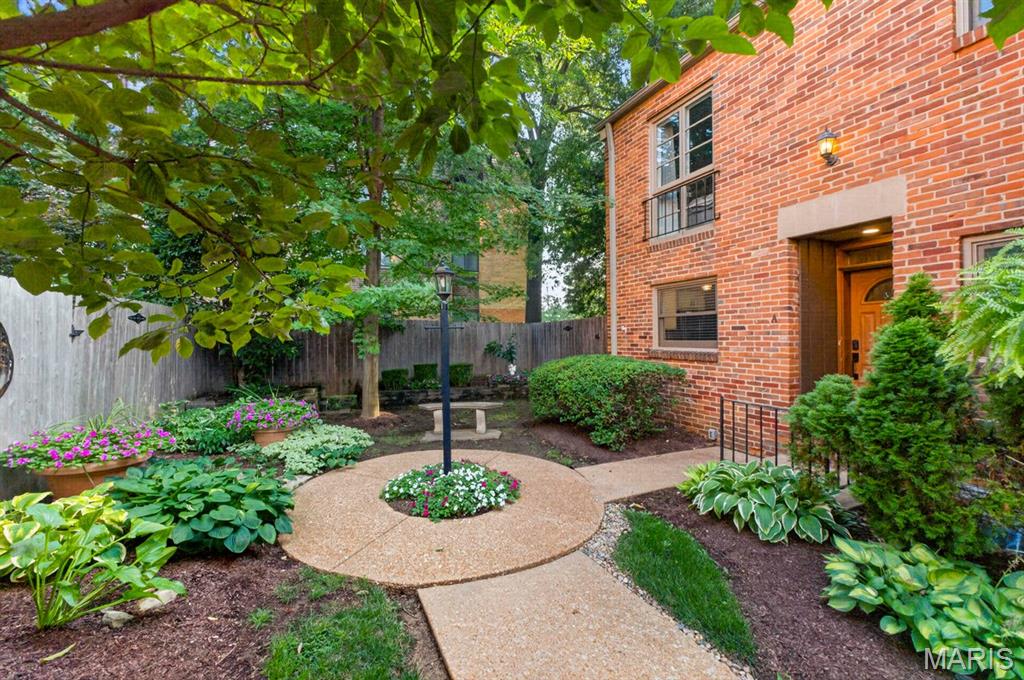 Rare opportunity to own this premium end-unit downtown Kirkwood townhome in an intimate, impeccably maintained community of just 10 residences centered around a beautifully landscaped courtyard. Pride of ownership shines throughout this full-brick, two-story townhome, showcasing architectural character paired with sophisticated modern updates and extensive improvements. Refinished oak hardwood floors, contemporary lighting, fresh neutral decor, beautifully renovated bathrooms, and thoughtful upgrades create a home that is truly move-in ready.

The inviting foyer opens to a light-filled living and dining area highlighted by a floor-to-ceiling brick fireplace with an updated surround. French sliding doors lead to a private, fenced garden patio with pergola—perfect for relaxing or entertaining. The updated kitchen features white cabinetry, granite countertops, stainless steel appliances, and picturesque courtyard views. A beautifully renovated powder room completes the main level.

Upstairs, you'll find a spacious primary bedroom with two closets and new blackout shades, along with a generous second bedroom. The beautifully renovated Jack-and-Jill bath is a true showstopper, featuring eye-catching blue-and-white patterned tile flooring, a marble-top vanity, crisp white cabinetry, updated lighting and fixtures, and a sleek glass-enclosed shower, creating a timeless, designer-inspired retreat.

The finished lower level is a true extension of the home's living space, showcasing a stunning recreation room with quality craftsmanship, including new drywall, all-new plumbing, added electrical outlets, and stylish light fixtures. Additional enhancements include updated lighting and electrical on the front and back porches, a newly added storage shed, and numerous thoughtful improvements that make this home truly exceptional.
All 3 Refrigerators included in sale of home.