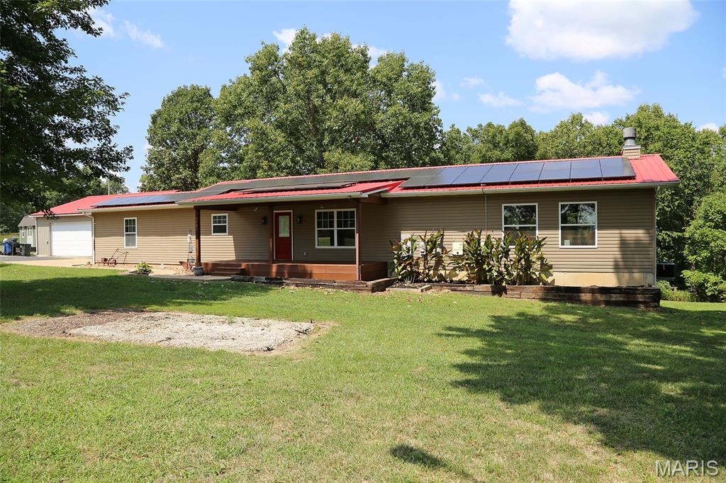 PRIVATE & UPDATED IN A PICTURESQUE SETTING! 2800+ TOTAL SQUARE FEET OF LIVING AREA! Enter off the lovely 24x8 covered front porch with 2 ceiling fans. Inside you'll find beautiful bamboo wood flooring throughout the main living areas--kitchen, breakfast room, and great room. Updated kitchen boasts stainless steel appliances, granite counters, mosaic tile backsplash, & cedar shaker cabinets. Crown molding throughout the kitchen, breakfast room, and both bedrooms. Primary Bedroom has a walk-in closet. Full hall bath with updated vanity. Stunning 30x24 great room is adjacent with handsome stone-front wood burning fireplace, wood beam mantle, open shelving on either side of fireplace, & 4 windows. French doors lead out to the 22x16 deck that overlooks the huge back yard & woods beyond. Steps (with gate) down to a covered patio. Walk-out lower level is partially finished. Enter to a large rec room area with sliding doors to the covered patio. Family room is adjacent. Full bath, washer/dryer area, & exterior door to additional small patio. 3rd Bedroom/Office area with walk-in closet could also be used as a sleeping area. Storage area rounds out the lower level. Attached 1-car side-entry garage off the kitchen has been converted to a storage area but could be reverted back. Detached 2-car front-entry oversize garage/outbuilding (30x30) with driveway to street. Metal Roof & Solar Panels added in 2016. New HVAC system in 2024. She shed is not included. Please see inclusions and exclusions in Agent Remarks.