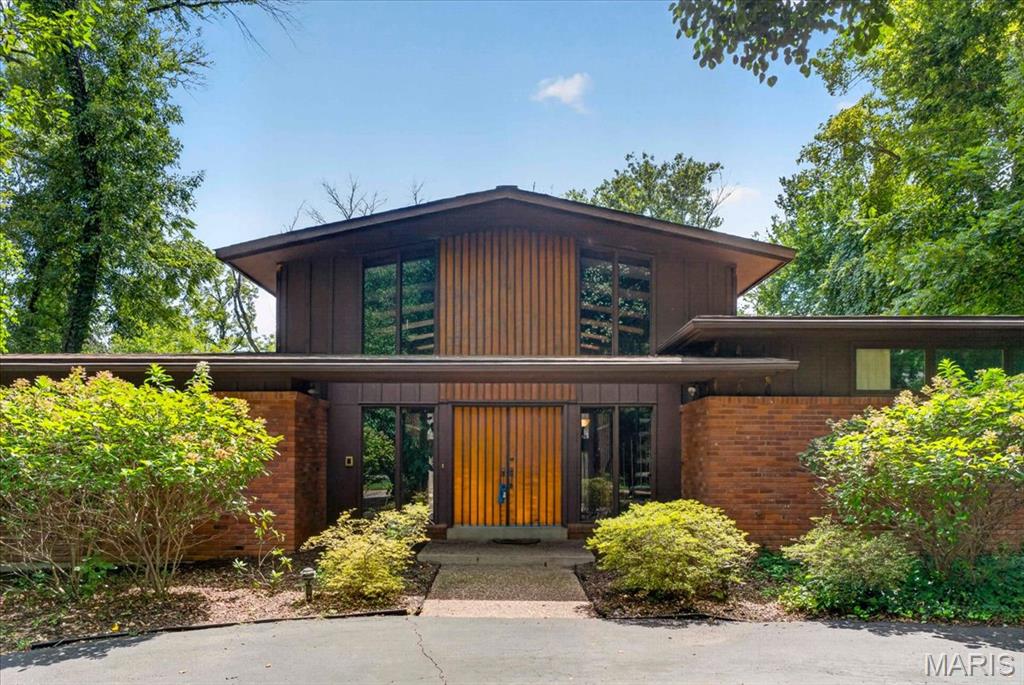 A rare offering in Frontenac's coveted Villa Coublay neighborhood. This 1968 residence presents an extraordinary opportunity to restore or reimagine a classic mid-century modern home. Situated on an expansive 1.19-acre parcel backing to Villa Duchesne's private drive, the home features the signature hallmarks of its era, including soaring ceilings, floor-to-ceiling great room windows, a towering two-story fieldstone fireplace and distinctive steel-frame construction. Distinctive copper and wood detailing highlight the home's architectural character. Offered strictly as-is, the home's solid structure, unique layout and architectural character provide an exceptional foundation for a modern transformation. Adding to its appeal, several significant infrastructure improvements have already been completed: 2022 water heater, and 2012 Frnc/2017 AC and 2016 Frnc/2022 AC multi-zone HVAC systems. Hardwood flooring beneath carpeting in the hallway and bedrooms offers another opportunity for restoration. Set within one of Frontenac's most sought-after enclaves, this distinctive property invites buyers and designers to create something truly personal in an extraordinary location. Schedule your private preview today.